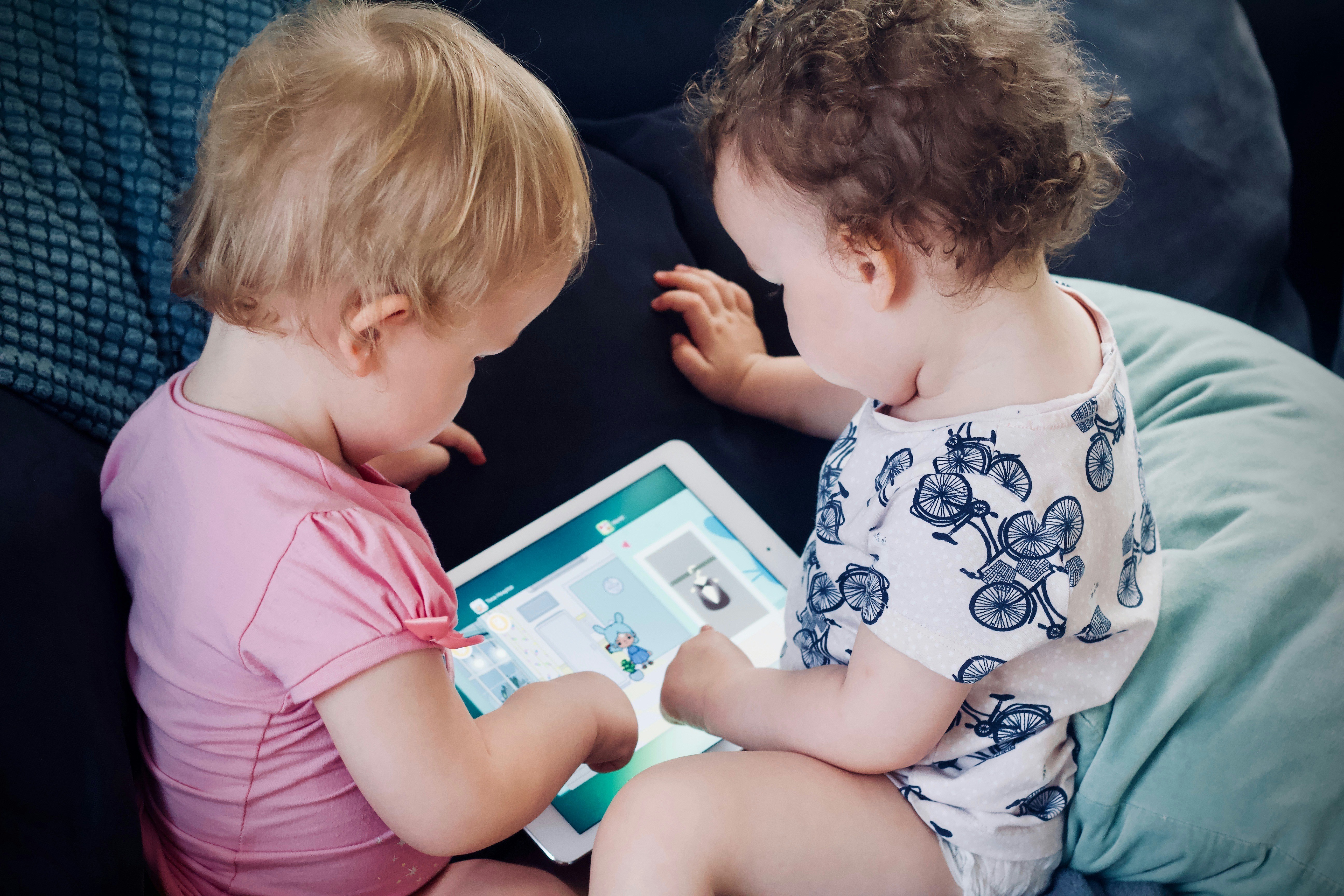 Deux enfants occupés sur leur tablette | Source : Unsplash