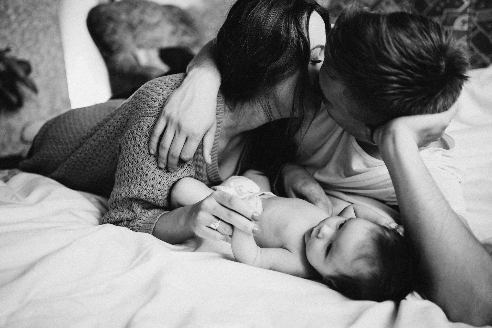 Couple avec leur nouveau-né sur le lit | Source : Pexels