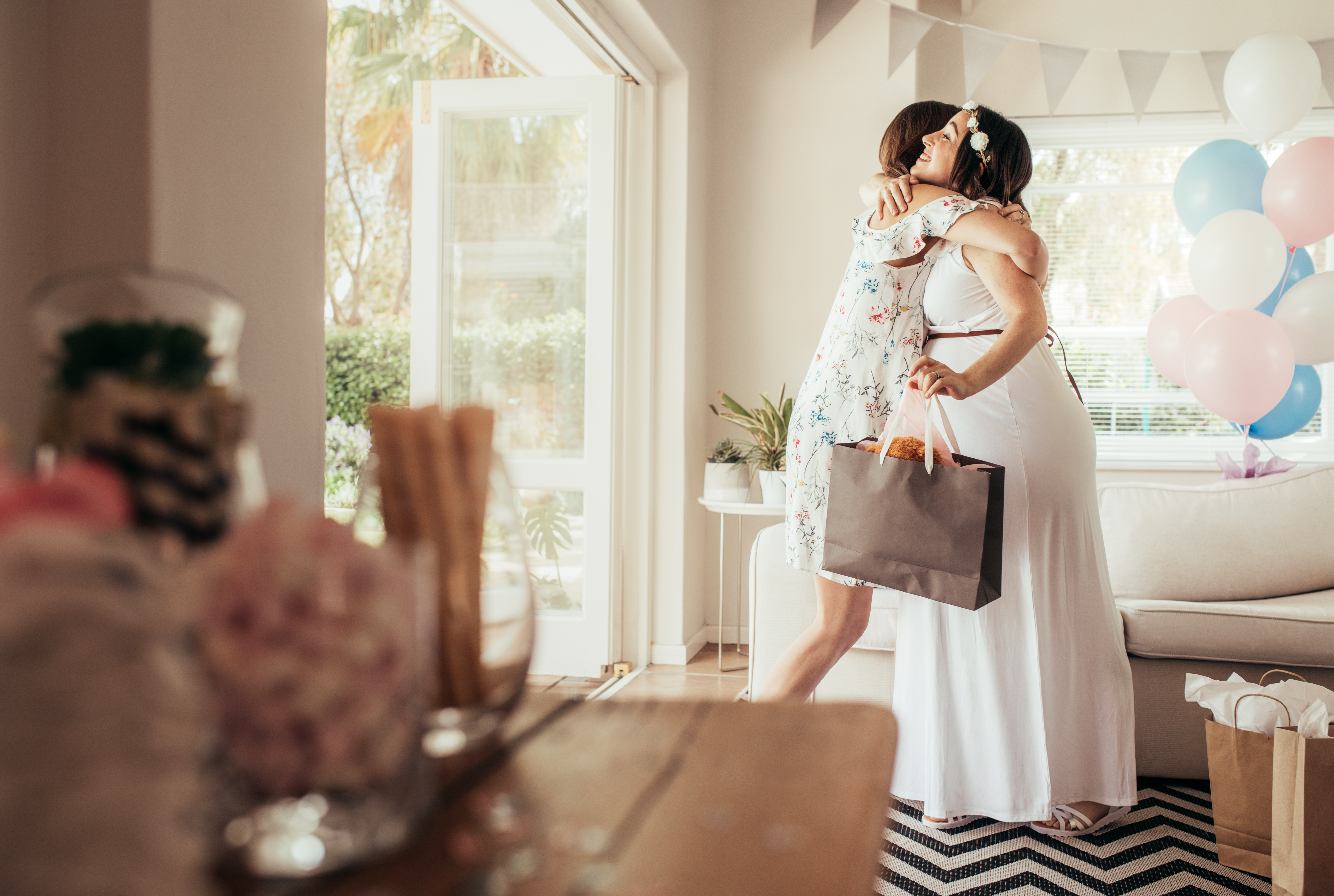 Femme prenant dans ses bras la future maman lors d'une fête prénatale | Source : Shutterstock