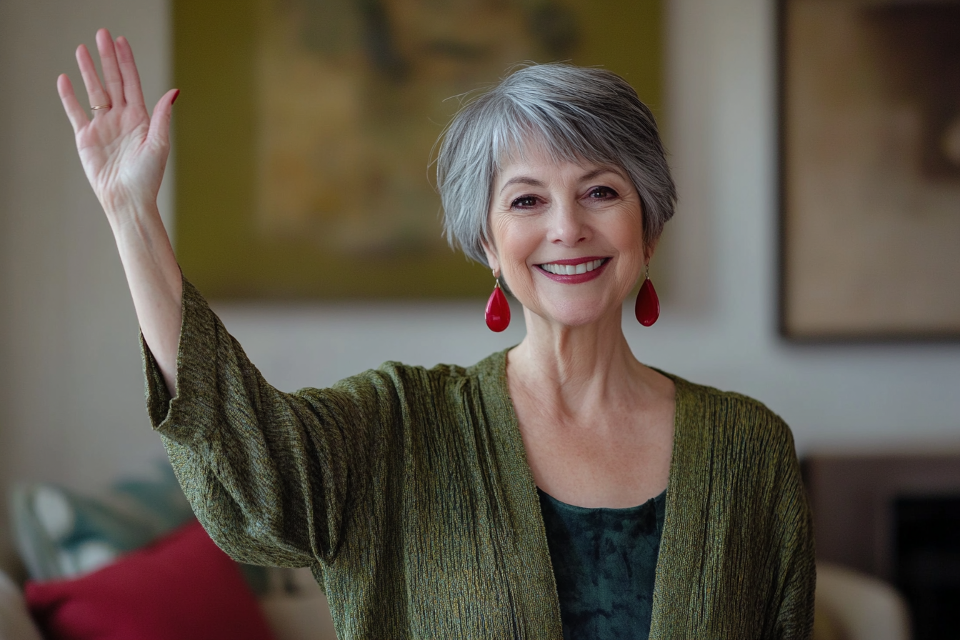 Une femme d'une soixantaine d'années fait un signe d'adieu dans un salon avec un sourire | Source : Midjourney