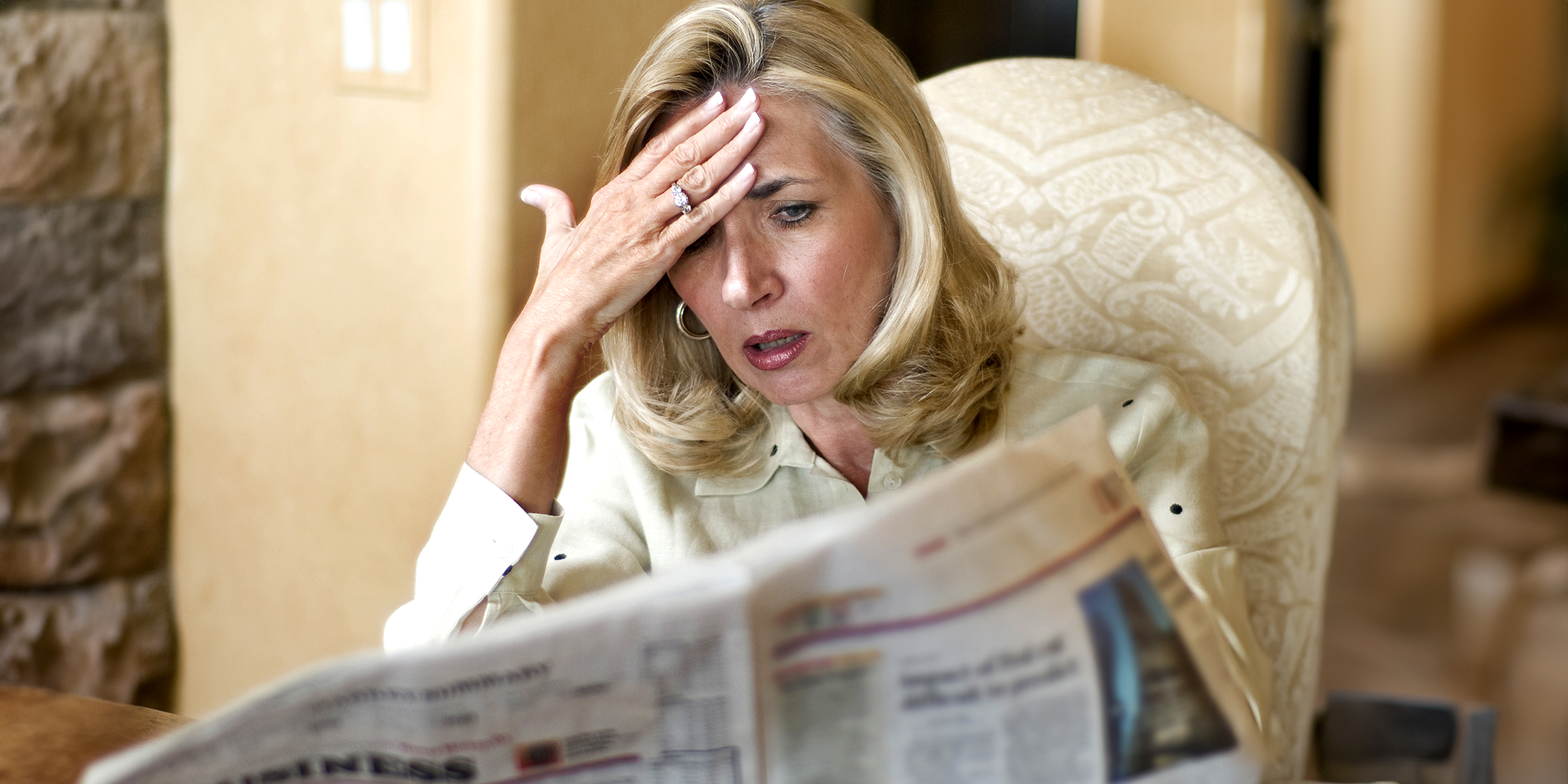 Une femme choquée lisant un journal | Source : Shutterstock