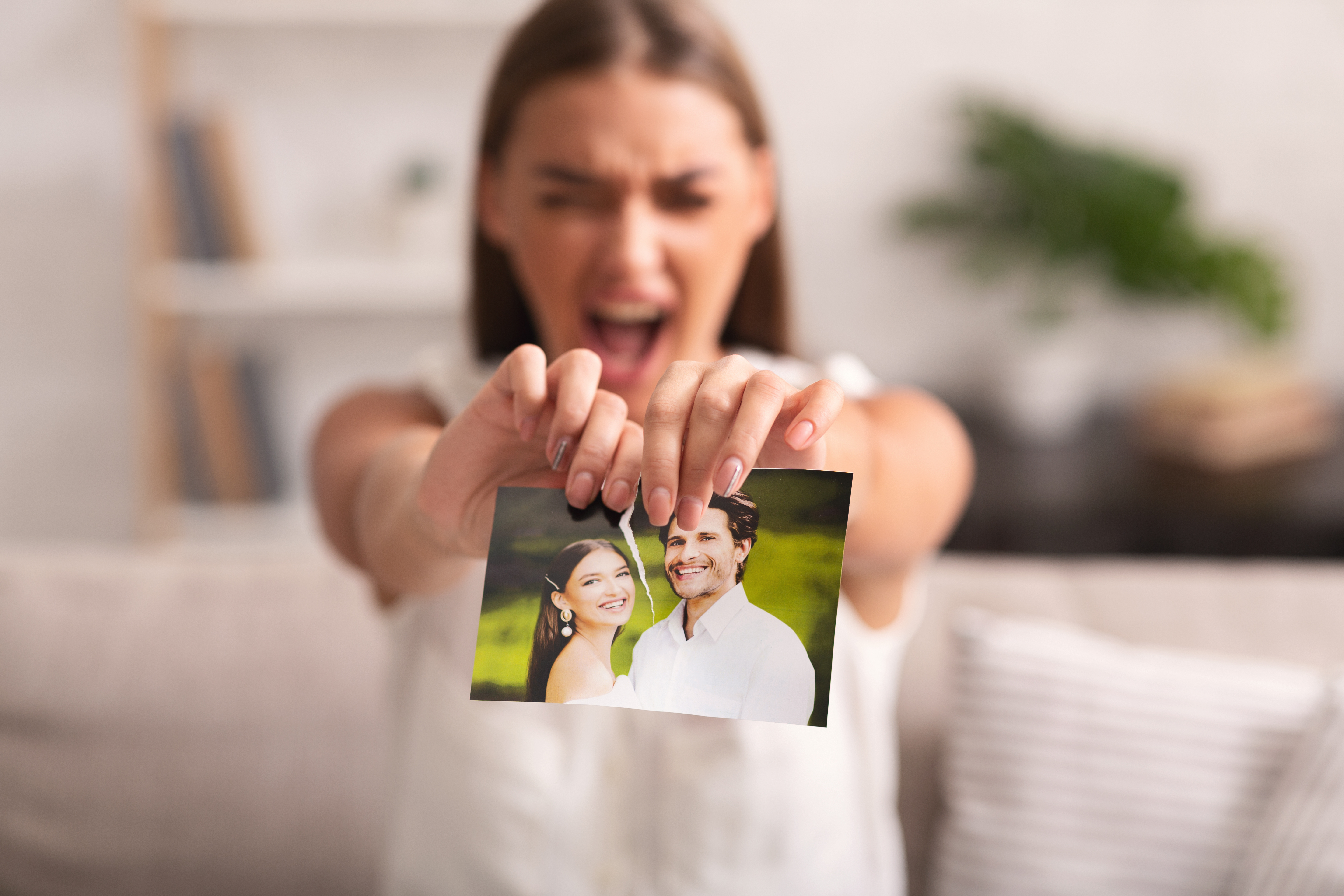 Une femme qui déchire une photo d'elle et d'un homme | Source : Shutterstock
