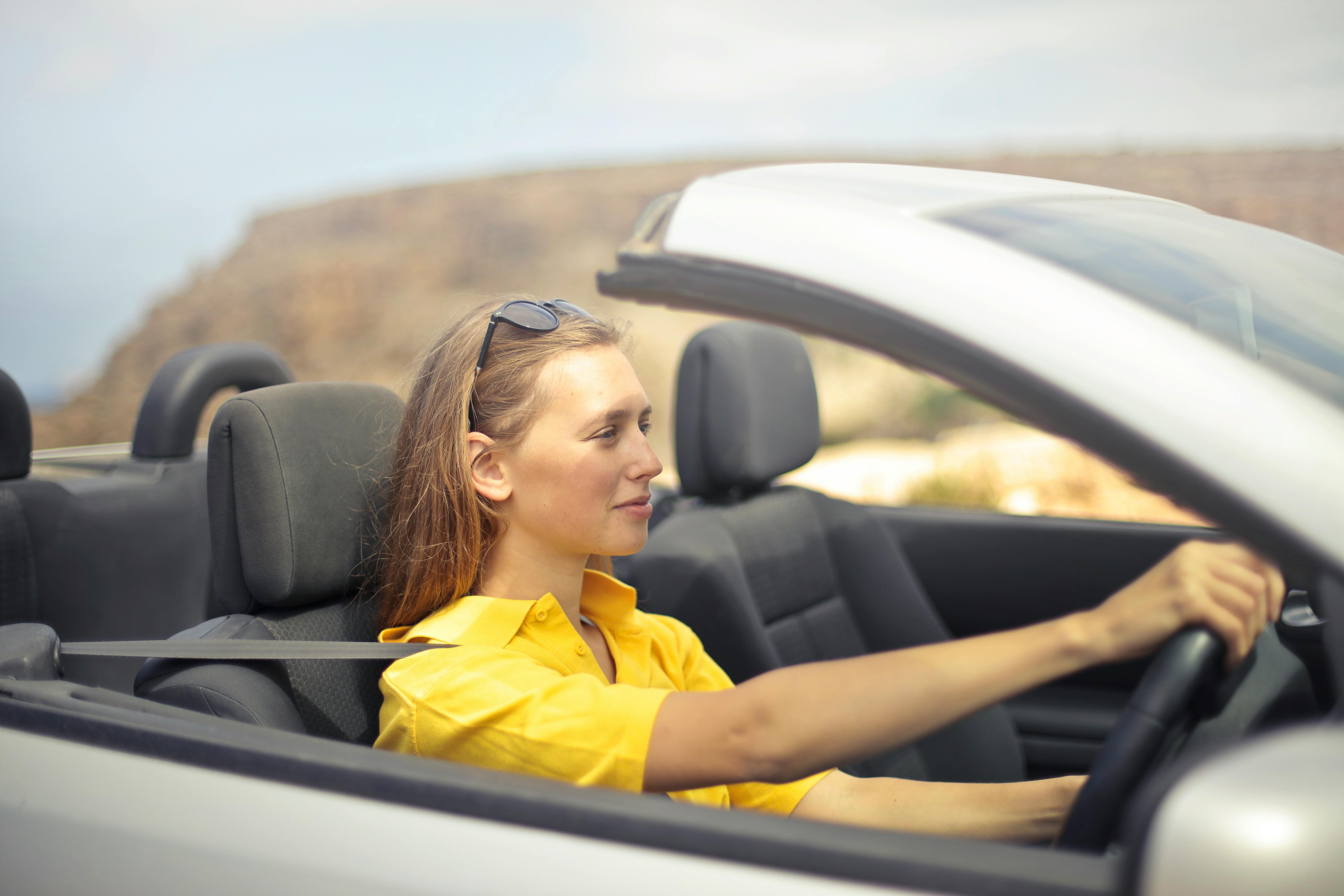 Une femme en chemise jaune au volant | Source : Pexels