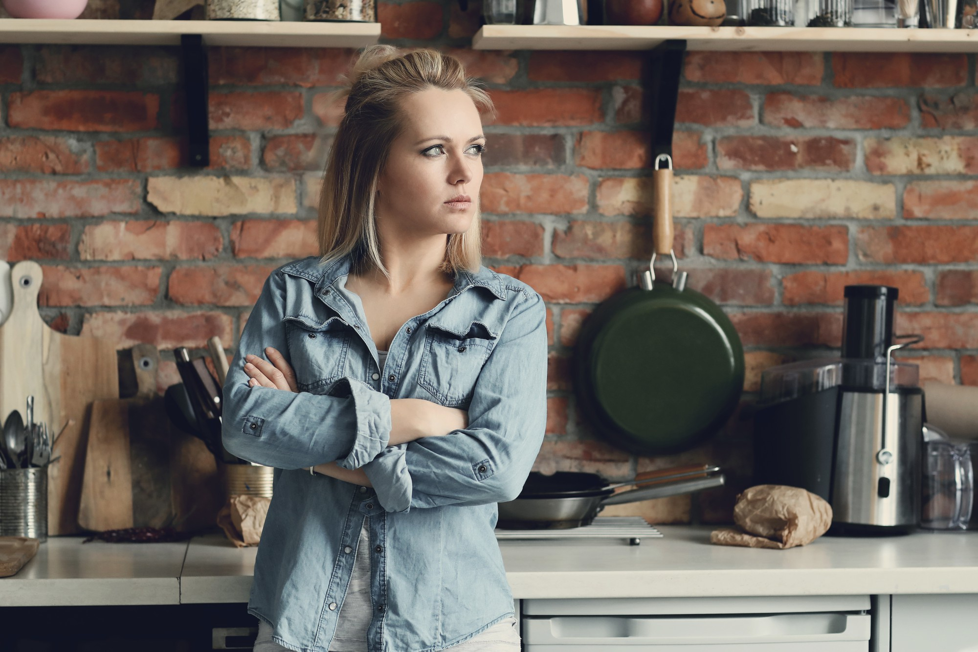 Une femme qui écoute quelque chose alors qu'elle est dans la cuisine | Source : Freepik