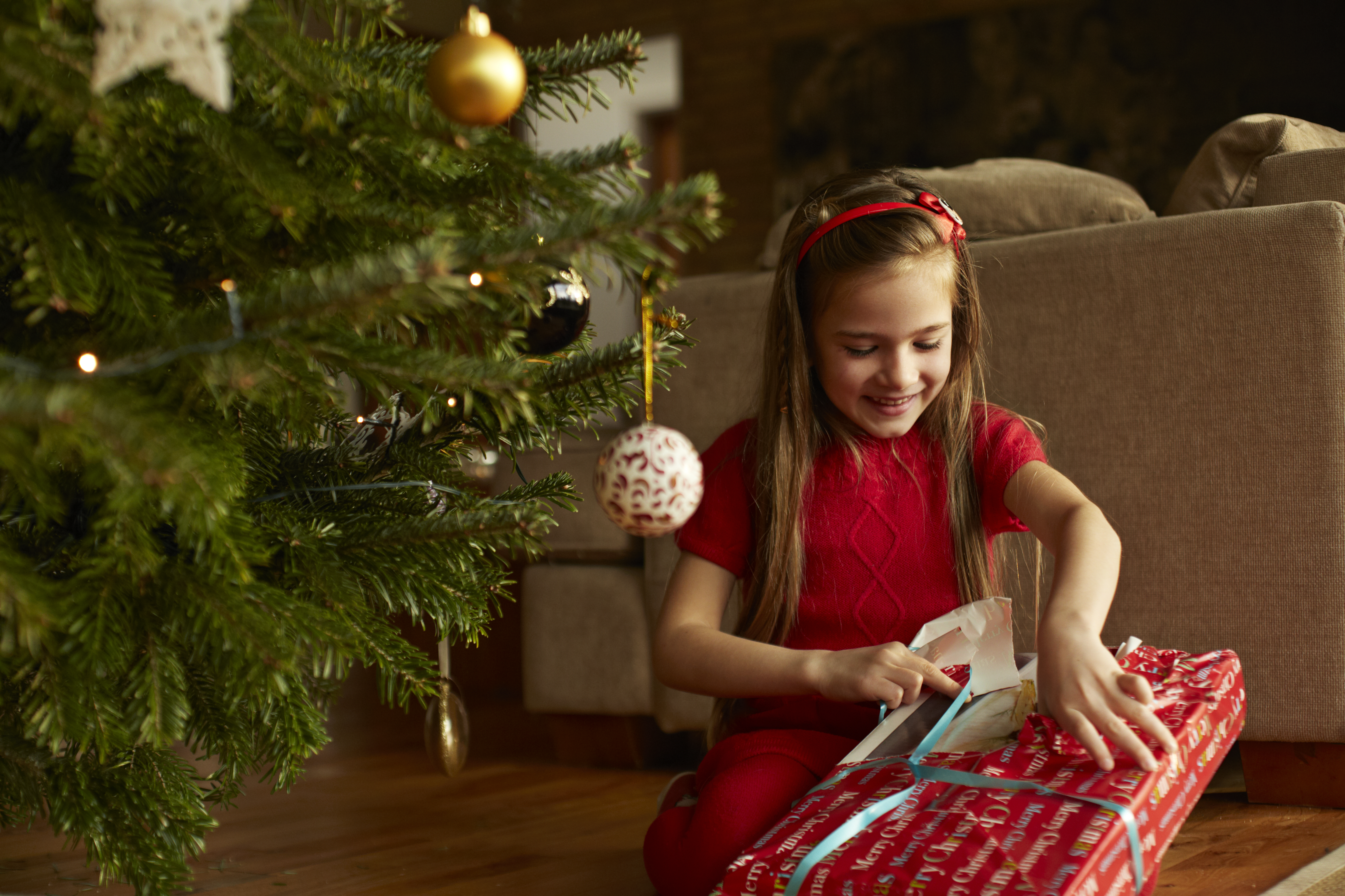 Petite fille ouvrant un cadeau de Noël | Source : Getty Images