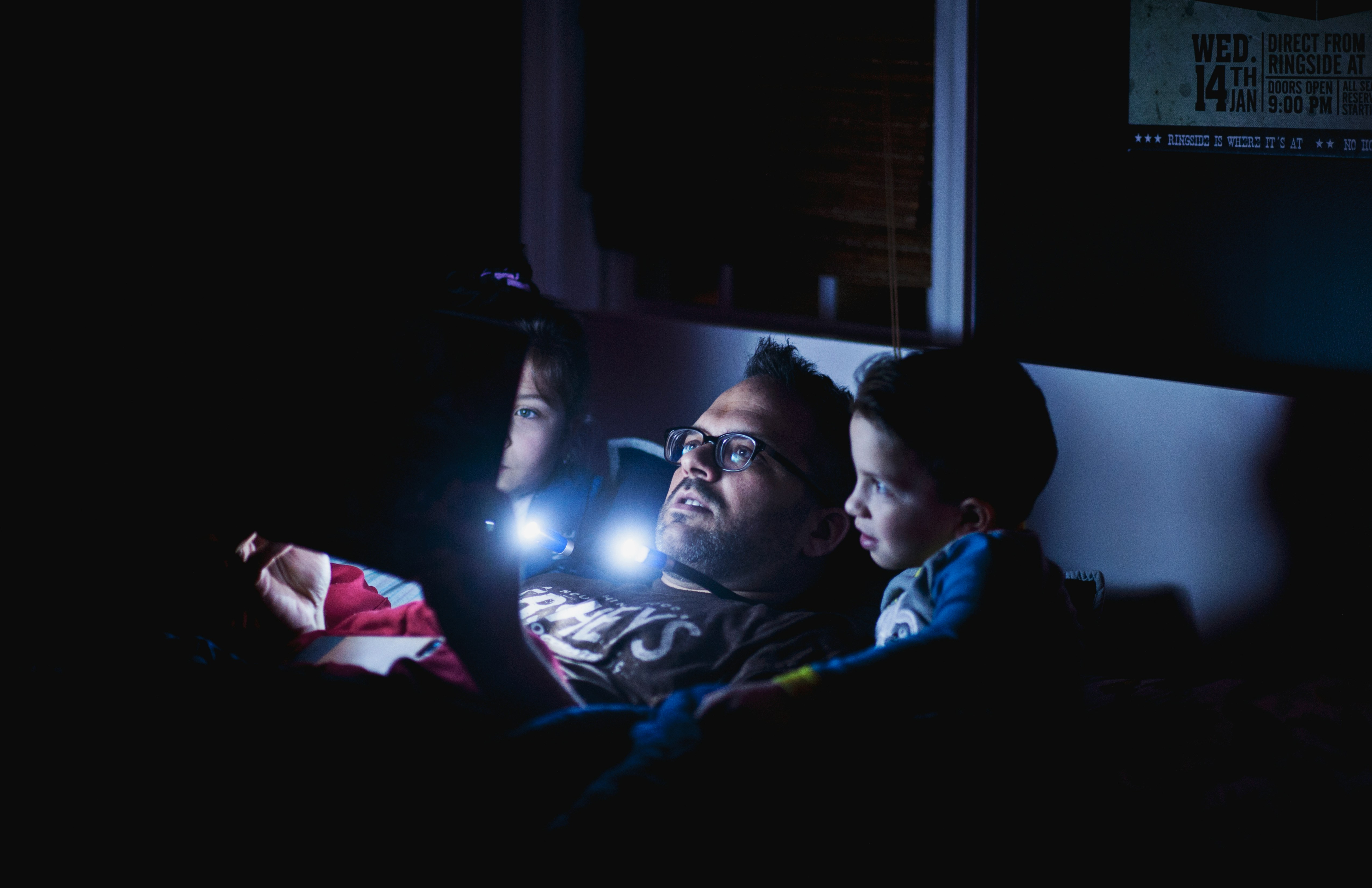 Un papa qui fait la lecture à ses enfants | Source : Unsplash