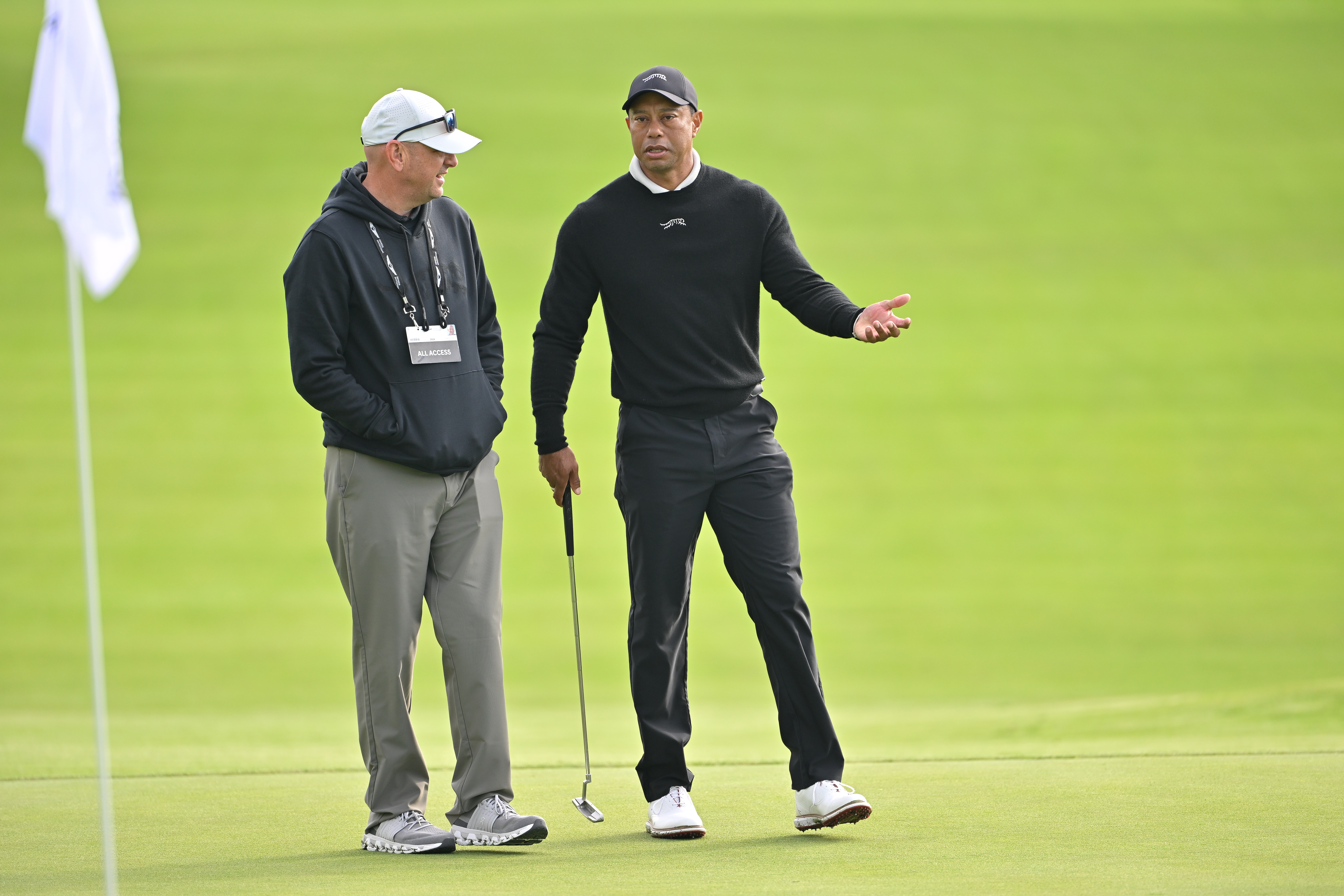 Rob McNamara et Tiger Woods ayant une conversation avant The Genesis Invitational à Pacific Palisades, Californie, le 14 février 2024 | Source : Getty Images