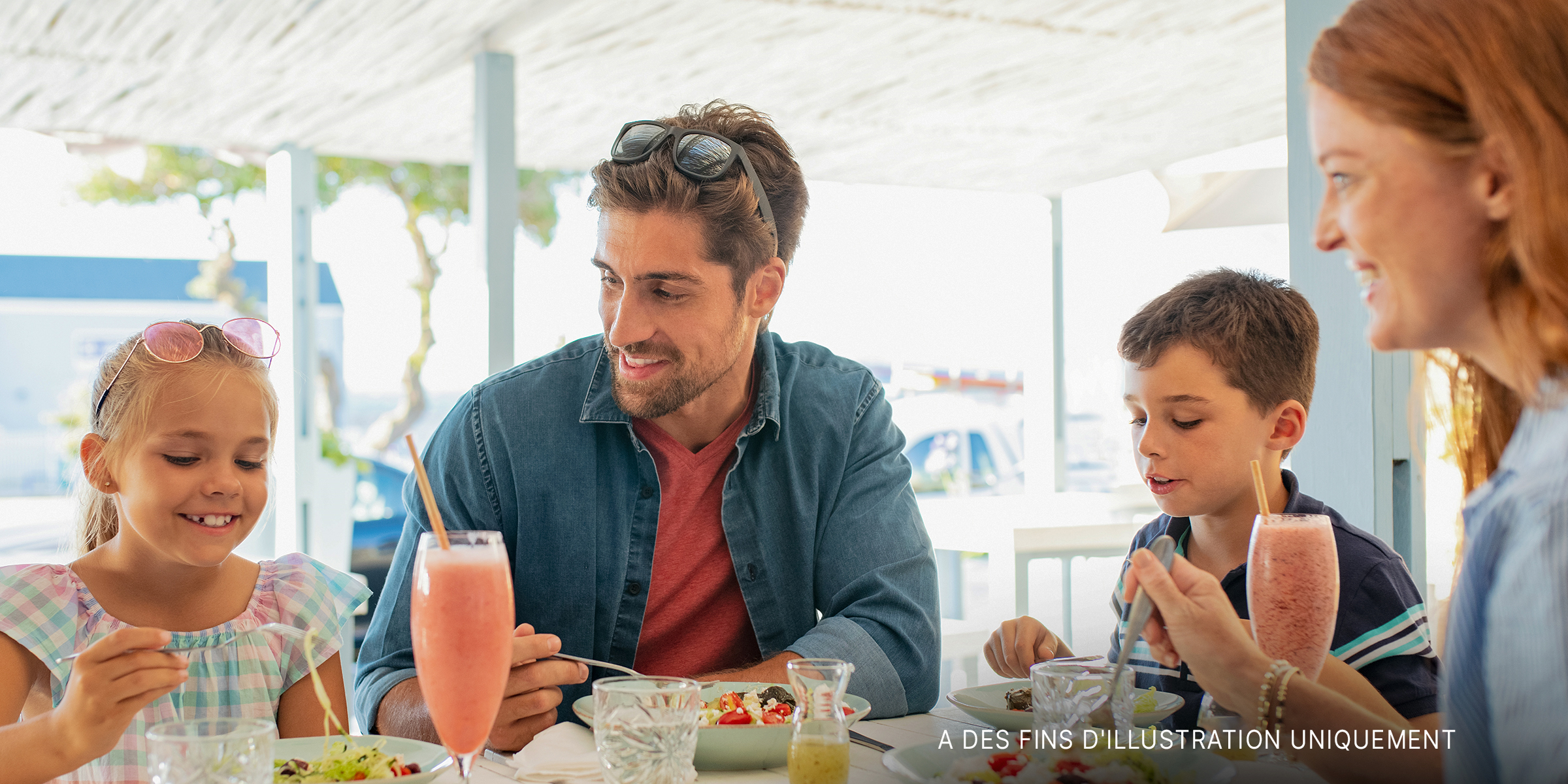 Une famille en train de manger au restaurant | Source : Shutterstock