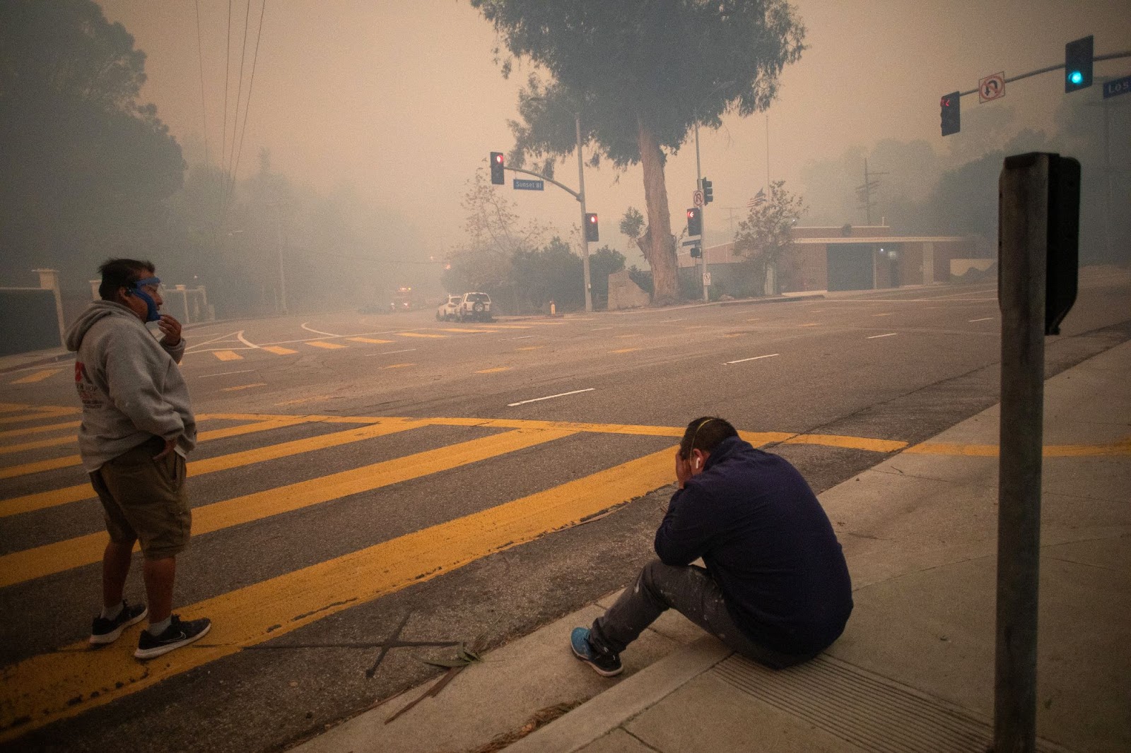 Des personnes s'arrêtent pour reprendre leur souffle alors qu'elles évacuent le long de Sunset Boulevard pendant l'incendie de Palisades, le 7 janvier 2025. | Source : Getty Images