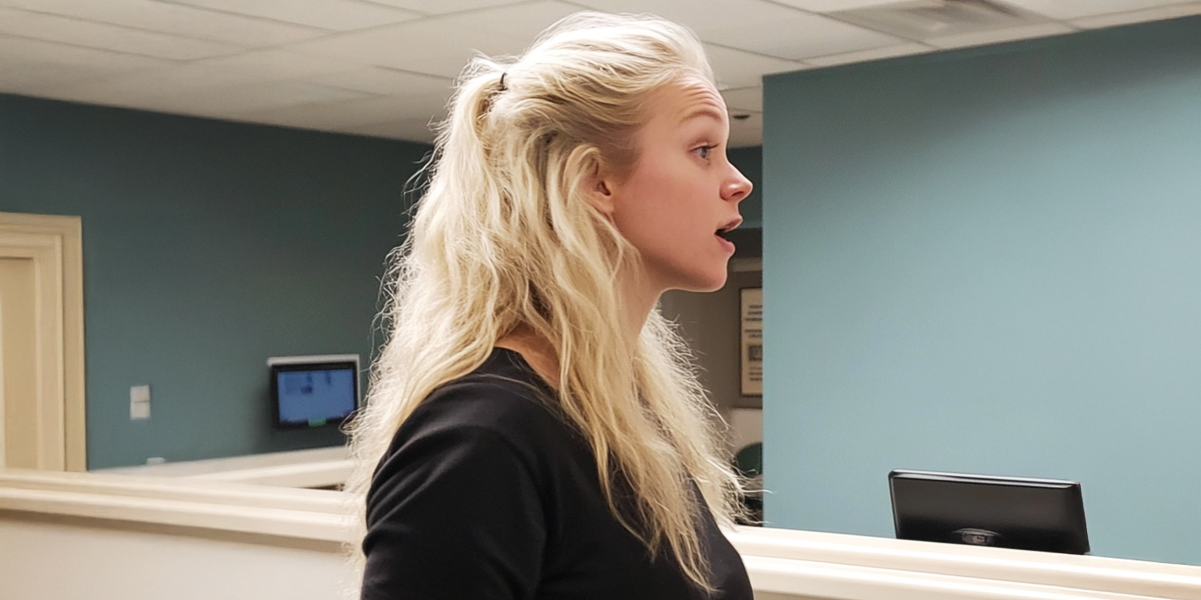 Une femme blonde debout dans un couloir d'hôpital | Source : Midjourney