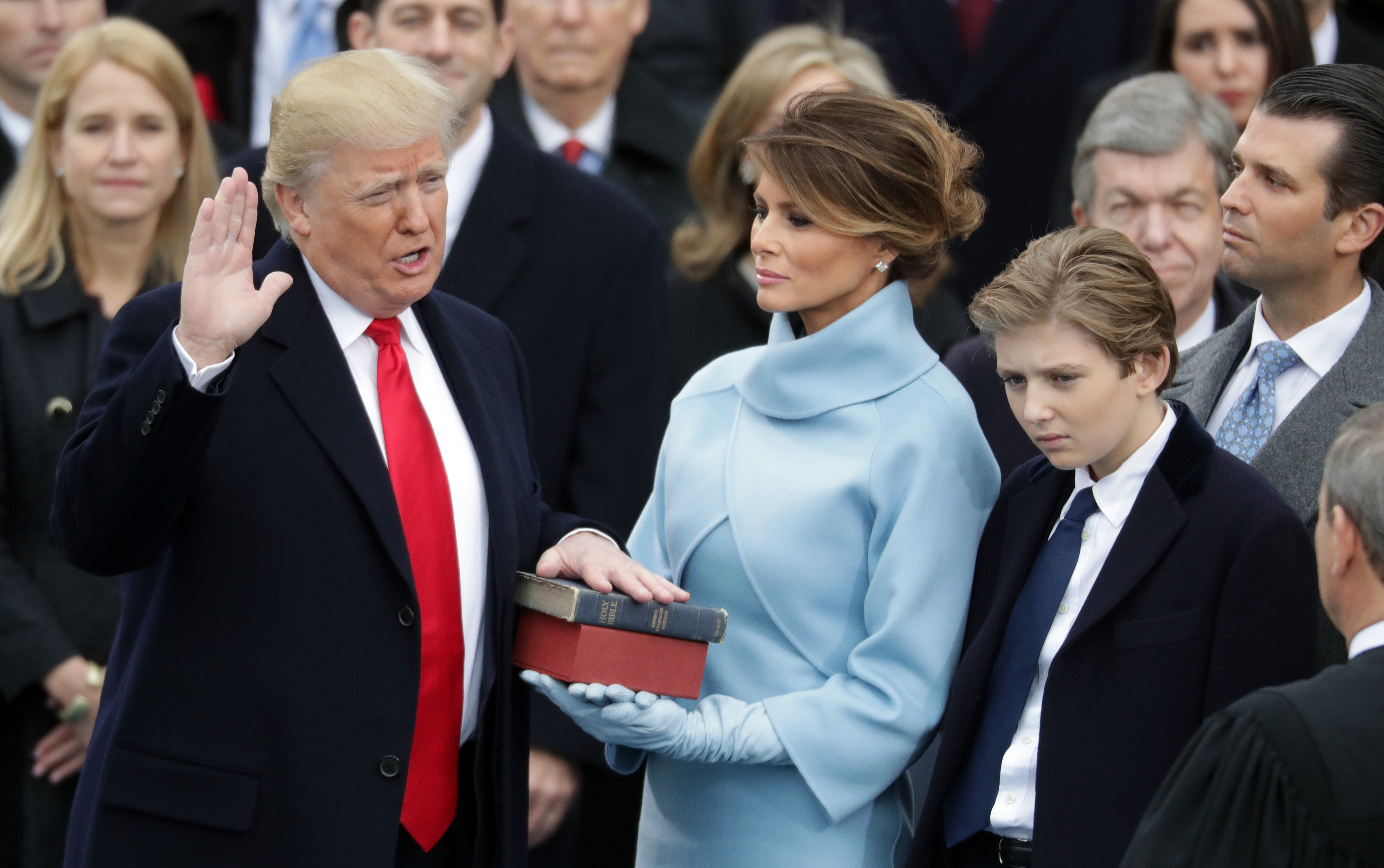 Donald Trump prête serment sous le regard de Melania Trump qui tient la bible et de Barron Trump, à Washington, DC | Source : Getty Images