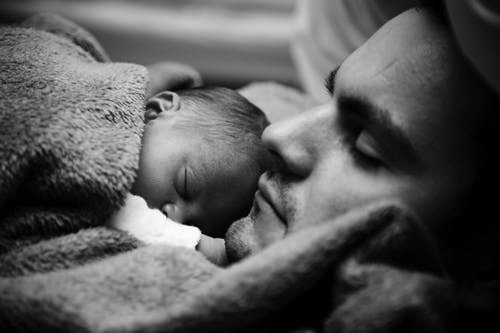 Un homme avec un nourisson sur sa poitrine | Photo: Pexels