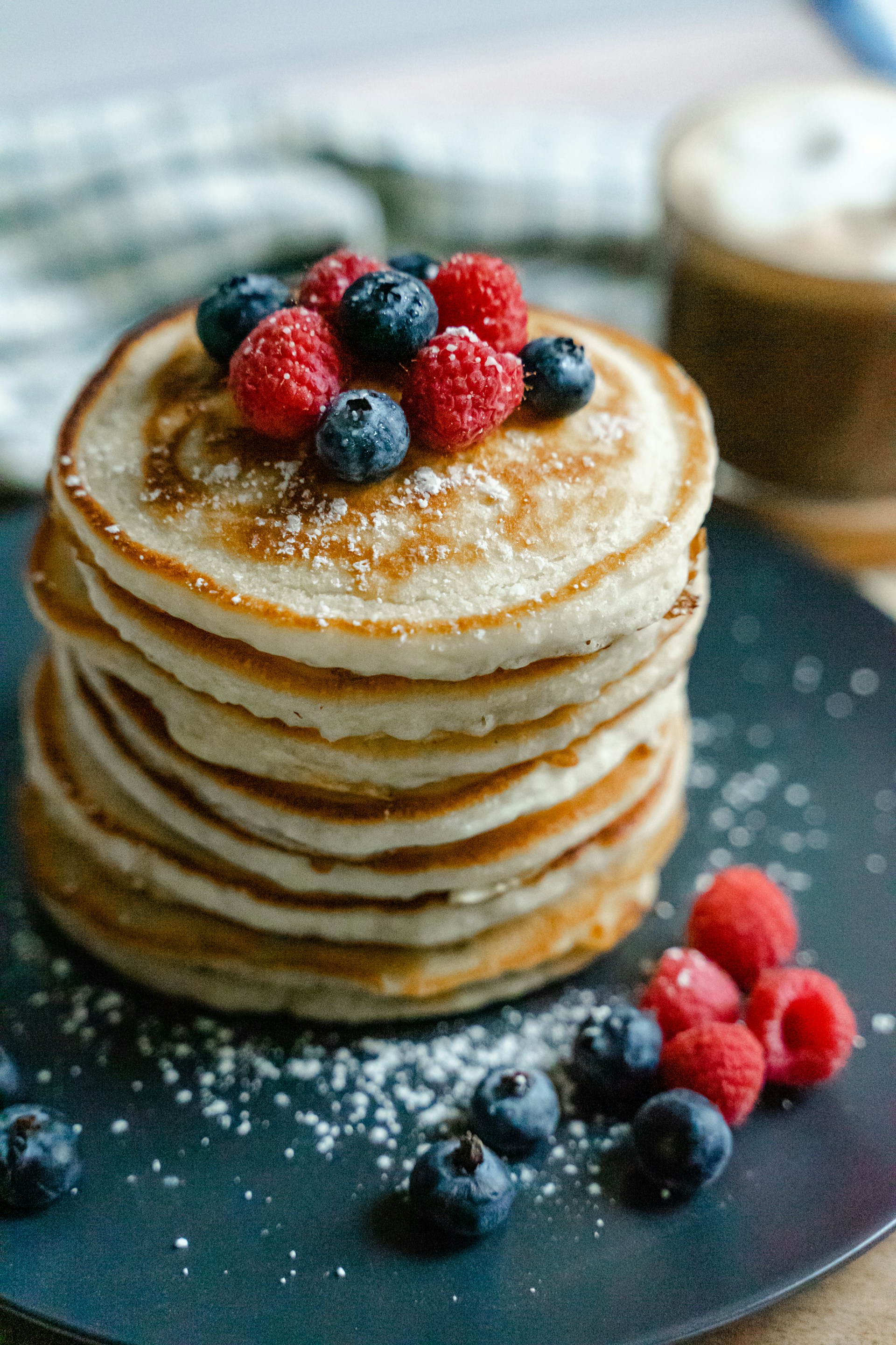 Une assiette de délicieuses crêpes avec des myrtilles et des framboises | Source : Unsplash
