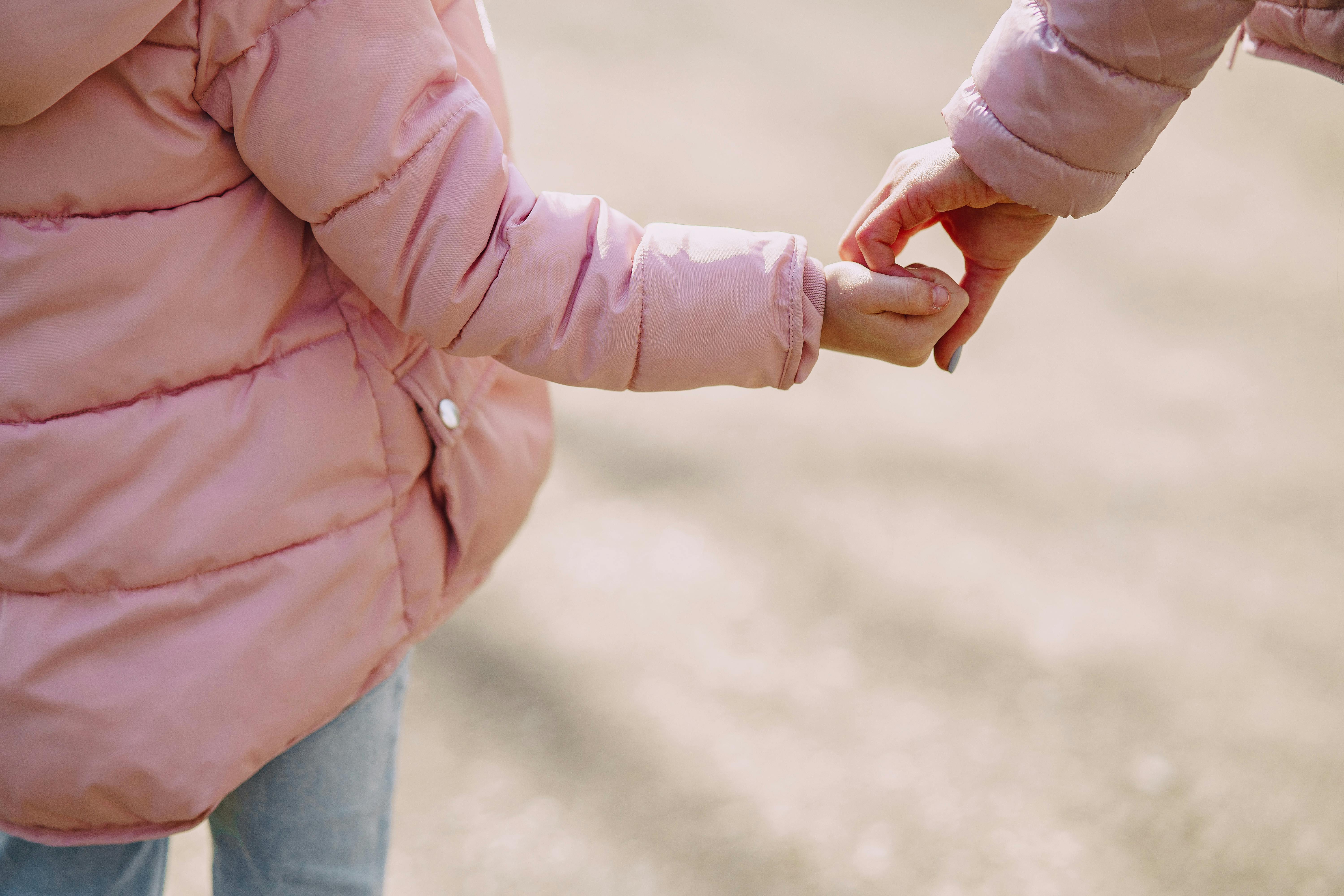 A mother holding her little girl's hand | Source: Pexels