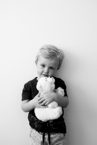 Un garçon tenant un ours en peluche | Photo : Unsplash