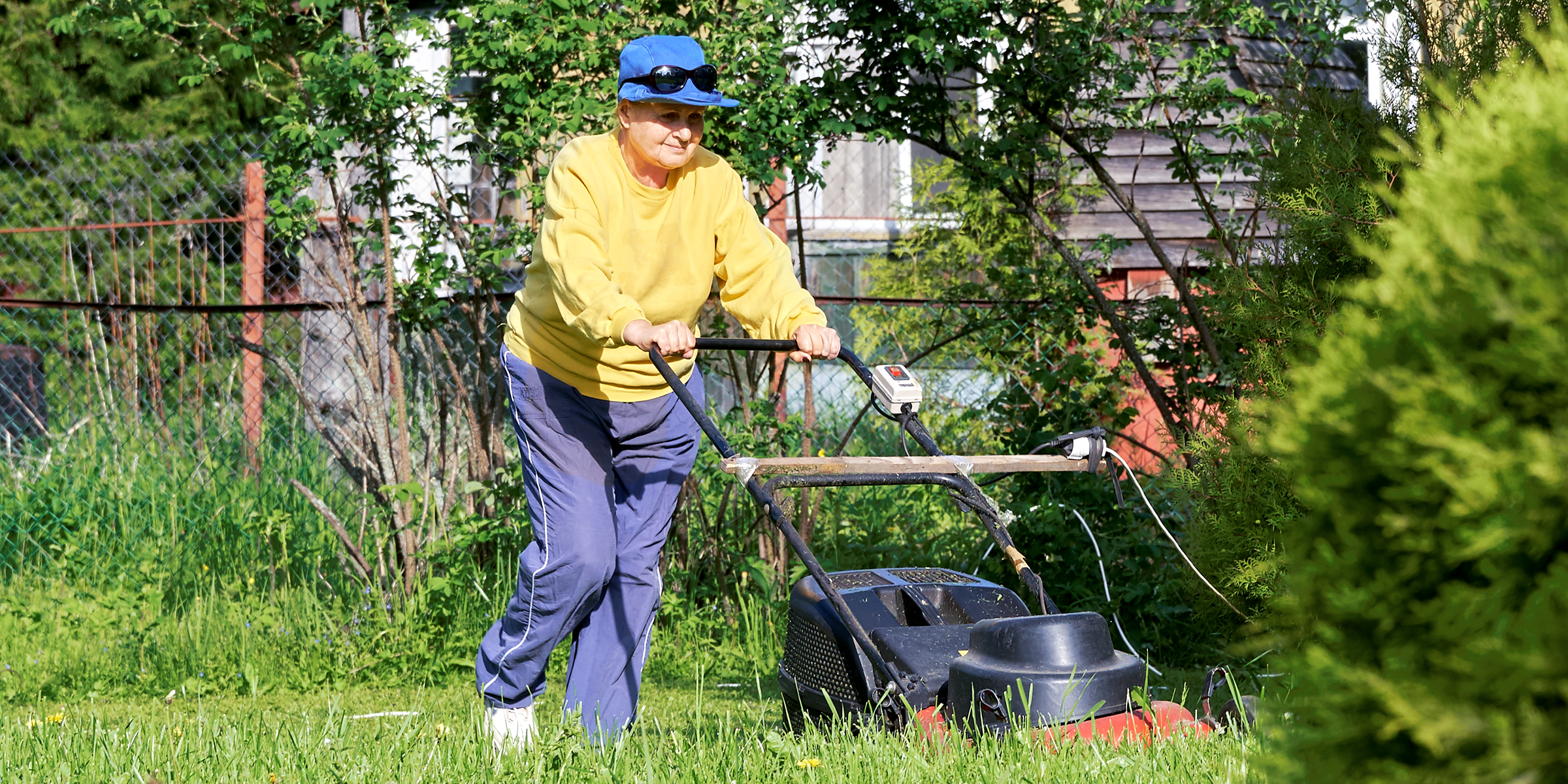 Une femme qui tond sa pelouse | Source : Shutterstock