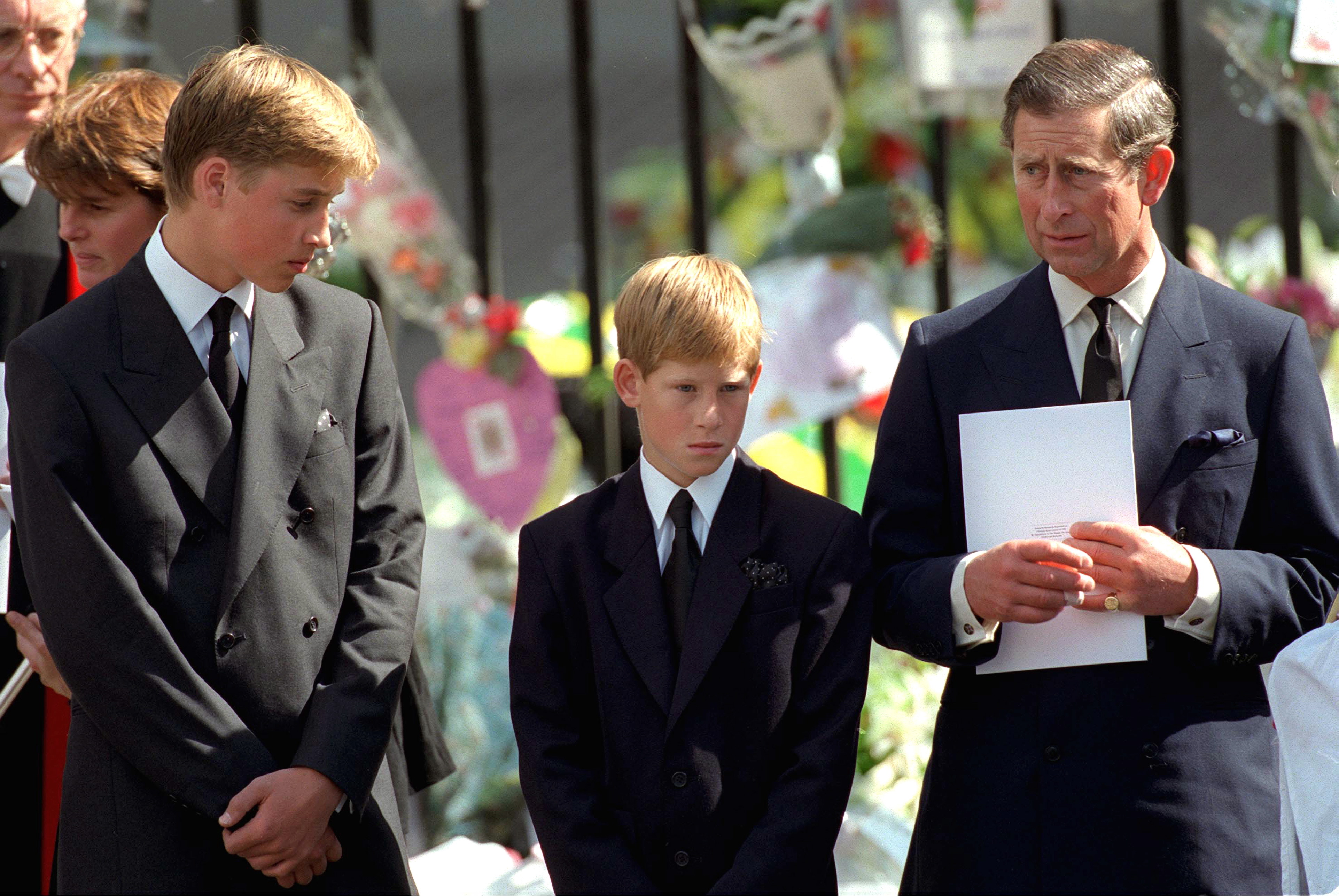Le prince William et le prince Harry avec le prince Charles tenant un programme funéraire à l'abbaye de Westminster pour les funérailles de Diana, princesse de Galles | Source : Getty Images