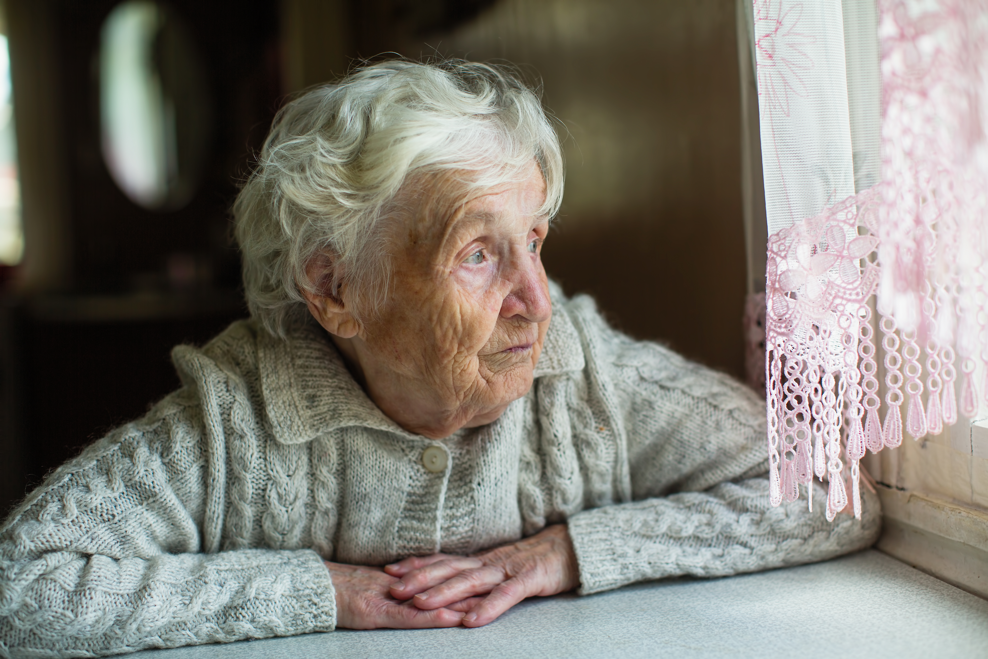 Une femme âgée regardant par la fenêtre | Source : Shutterstock