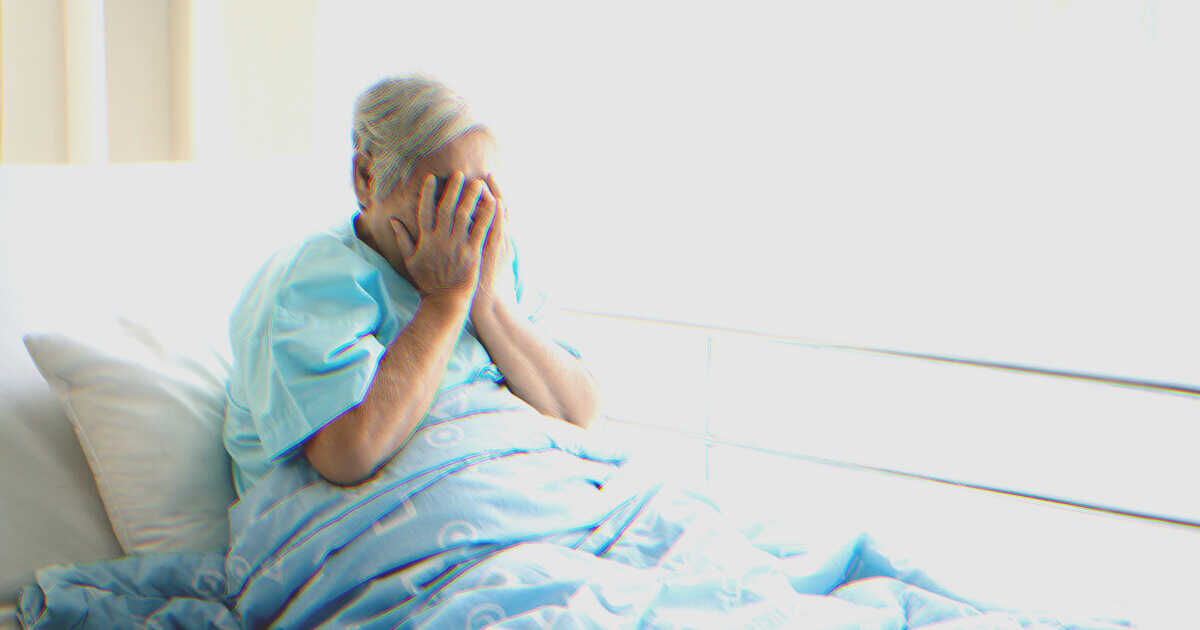 Mulher chorando em uma cama de hospital | Fonte: Shutterstock