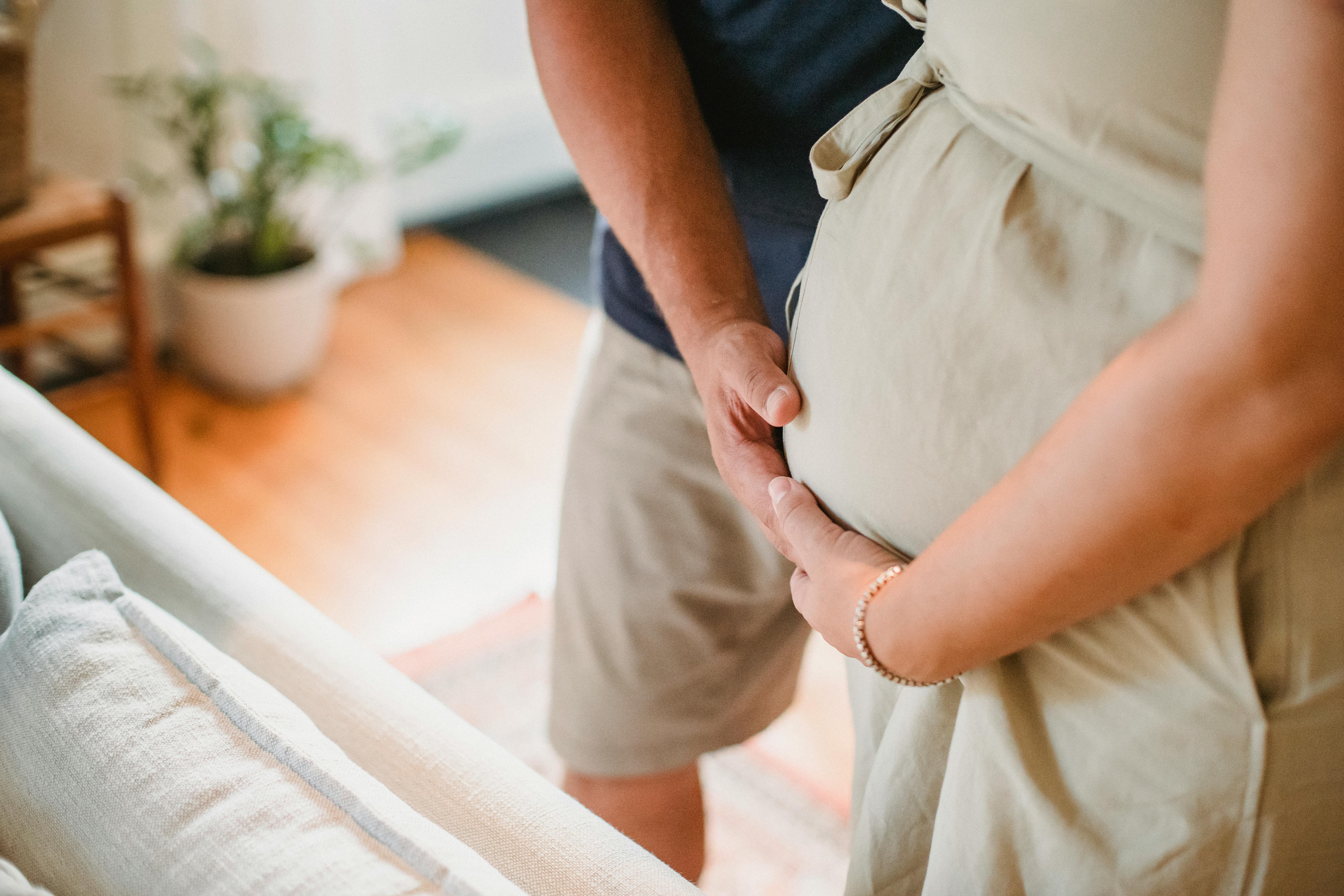 Un homme et une femme caressent un ventre de femme enceinte | Source : Pexels