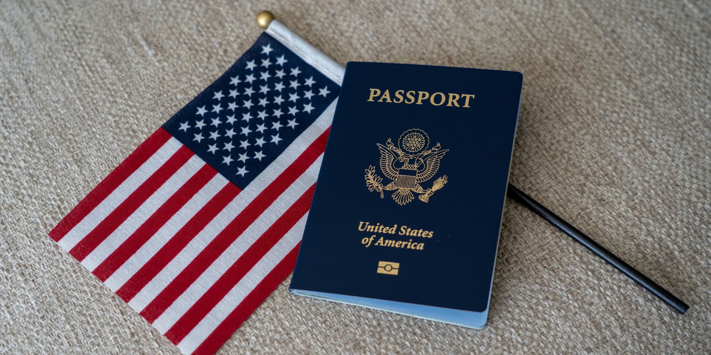 Un passeport américain à côté d'un drapeau américain | Source : Shutterstock