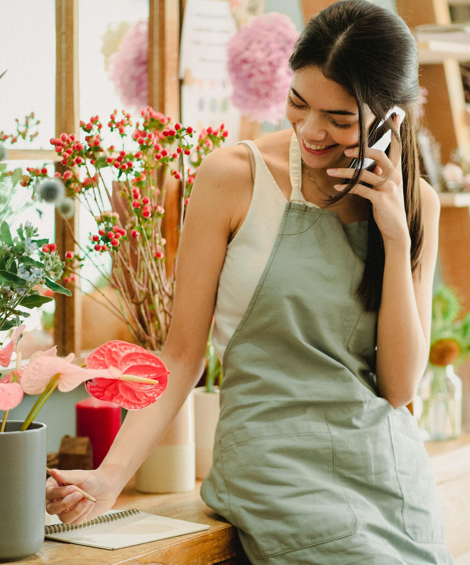 Une femme heureuse en tablier sur un appel | Source : Pexels