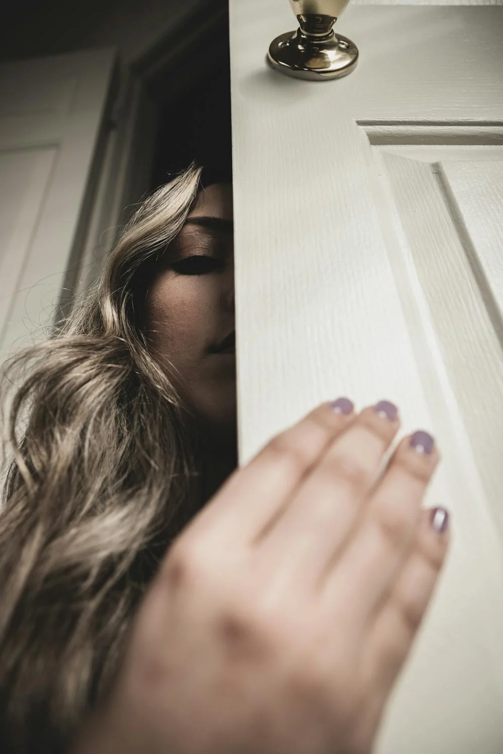 Une femme qui jette un coup d'œil derrière une porte | Source : Pexels