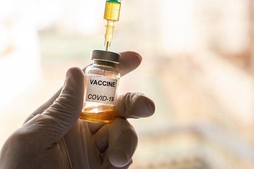 Main tenant le vaccin Covid-19. | Photo : Getty Images
