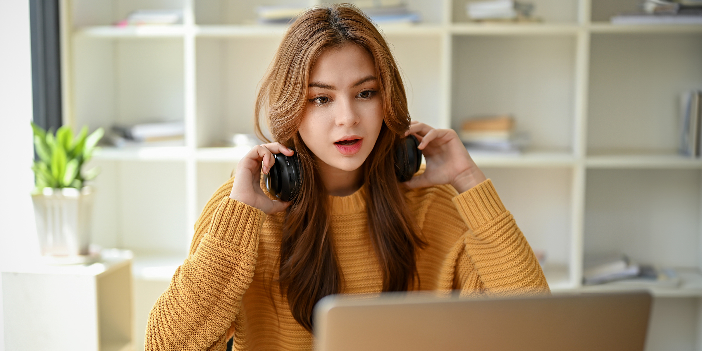 Une femme choquée alors qu'elle regarde l'écran d'un ordinateur portable | Source : Shutterstock