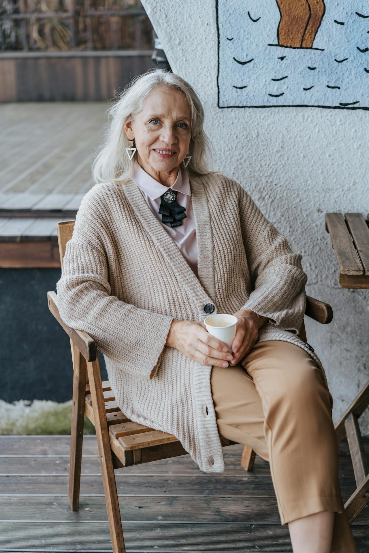 Une femme âgée joyeuse assise sur une chaise | Source : Pexels