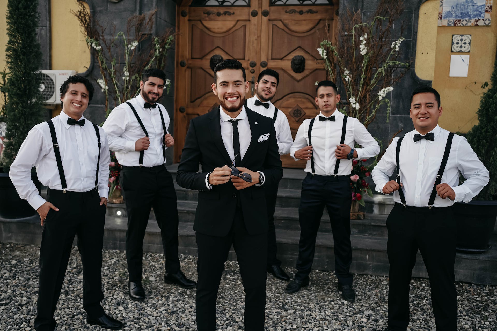 Un hombre de pie con sus padrinos de boda | Fuente: Pexels