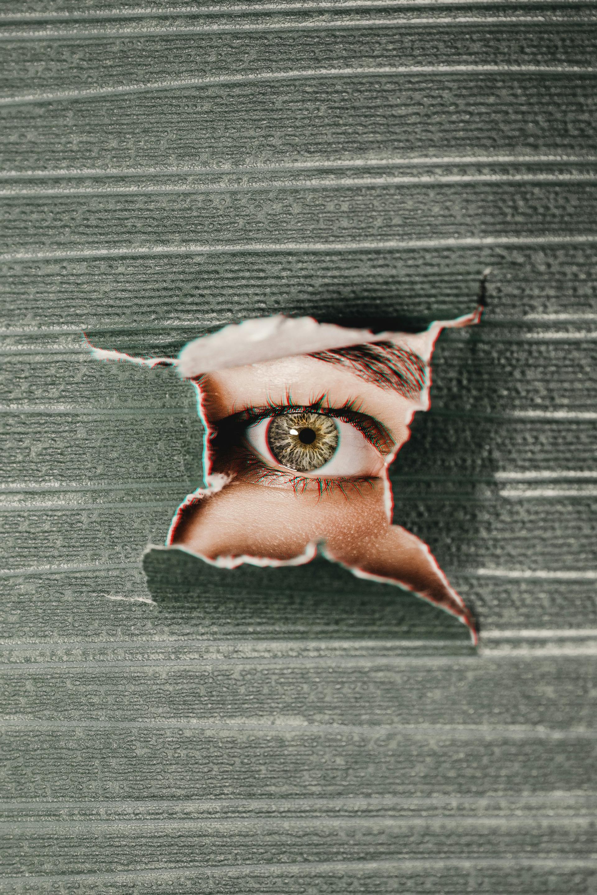 Un œil qui regarde à travers un mur | Source : Pexels