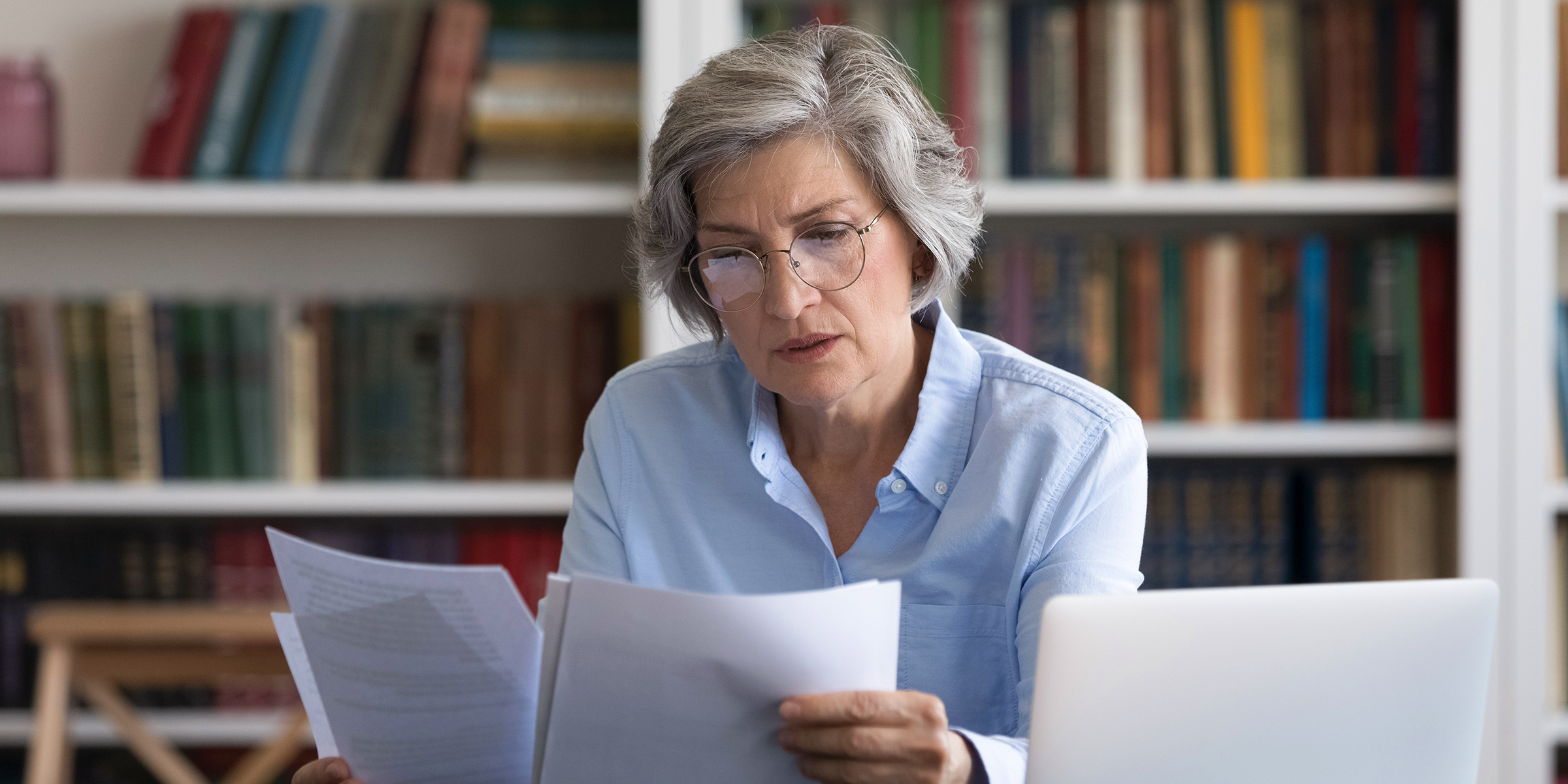 Une dame âgée en train de lire des documents | Source : Shutterstock