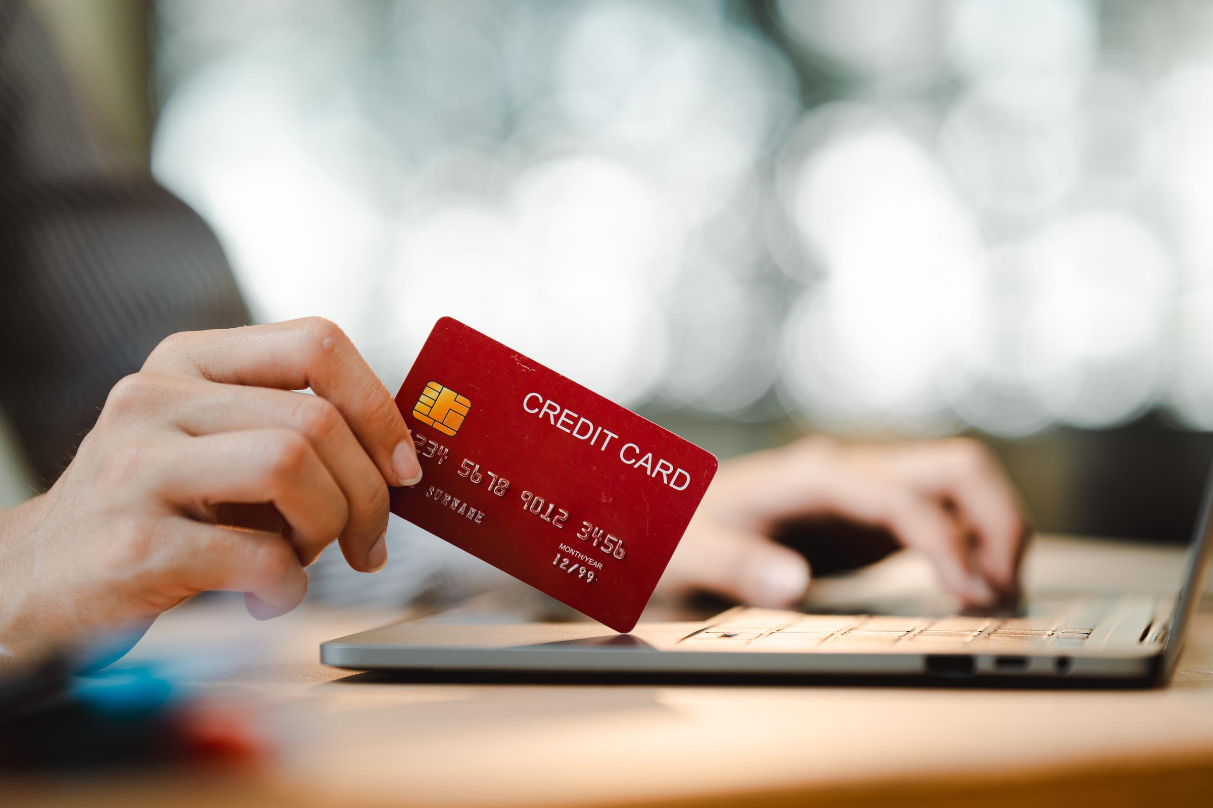 Une personne en train de saisir des informations de carte bancaire sur un ordinateur portable | Source : Shutterstock