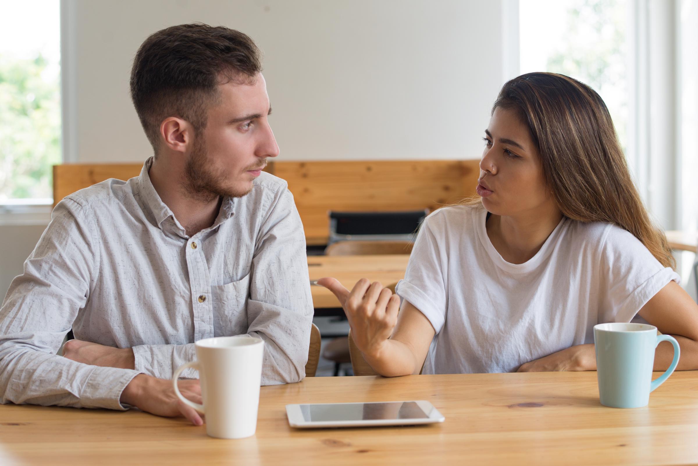 Un couple en train de discuter sérieusement | Source : Freepik