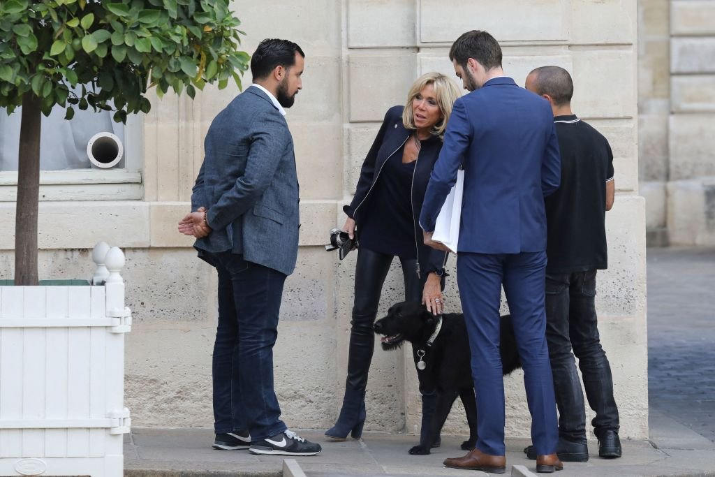 L'épouse du président français, Brigitte Macron (2-L), s'entretient avec des collègues, dont l'agent de sécurité principal de l'Élysée, Alexandre Benalla, à côté du chien du président, Nemo (R), au palais de l'Élysée à Paris, le 12 octobre 2017. | Photo : Getty Images