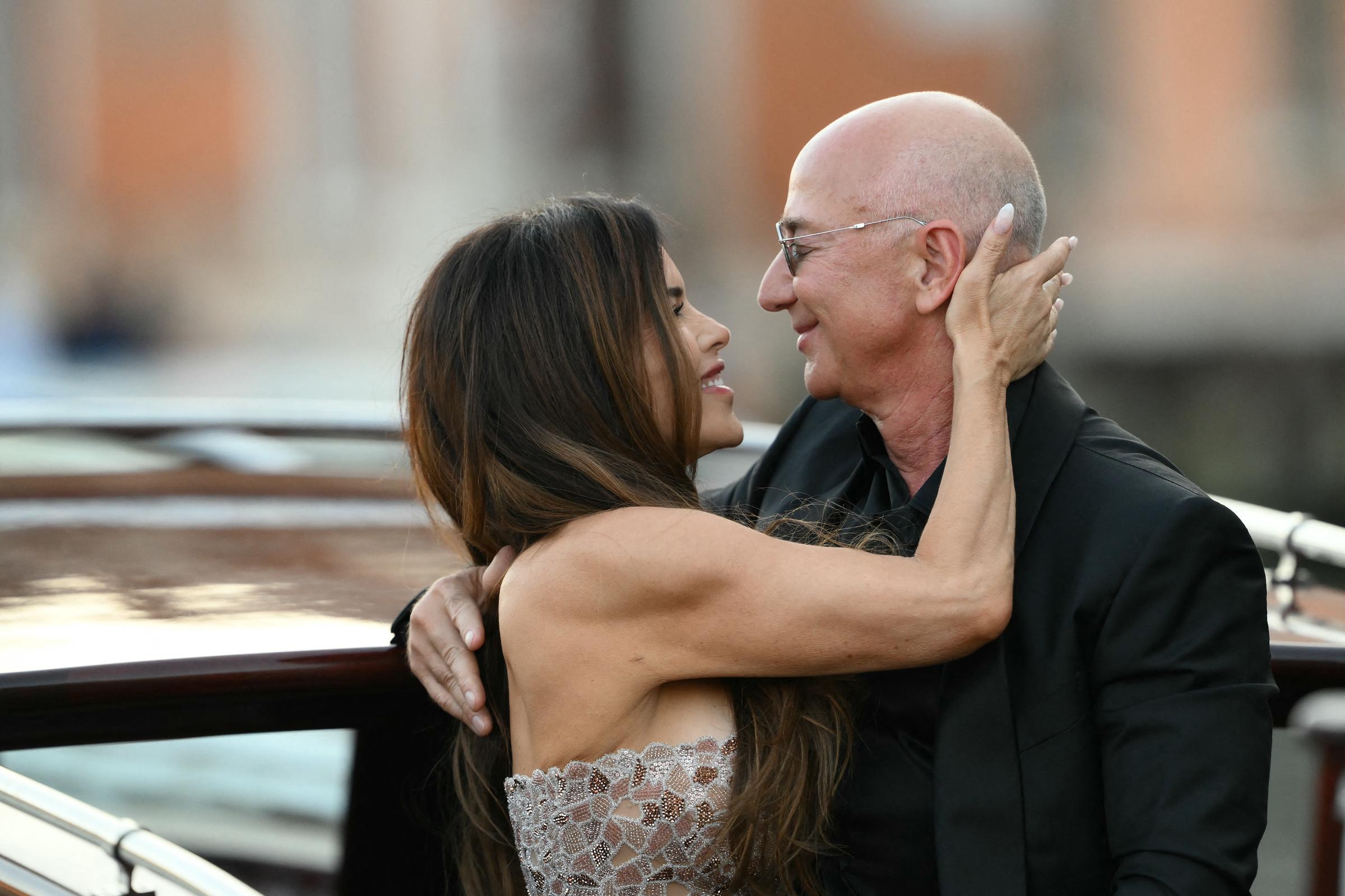 Lauren Sánchez regarde Jeff Bezos avec amour, sa main posée délicatement sur le côté de sa tête, alors qu'ils partagent un moment intime à bord du bateau, leurs visages proches et leurs sourires tendres.