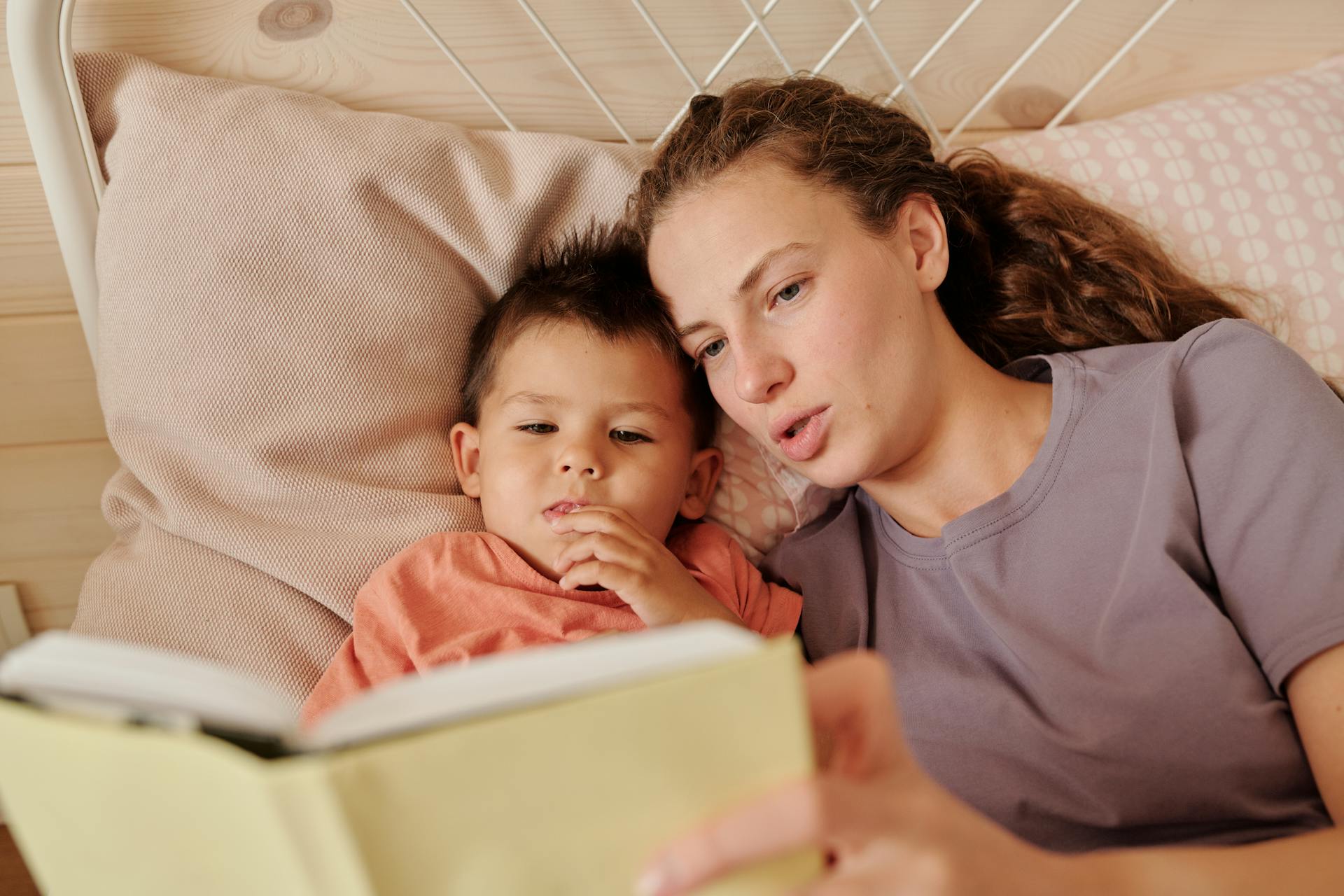 Une mère lisant un livre à son fils | Source : Pexels