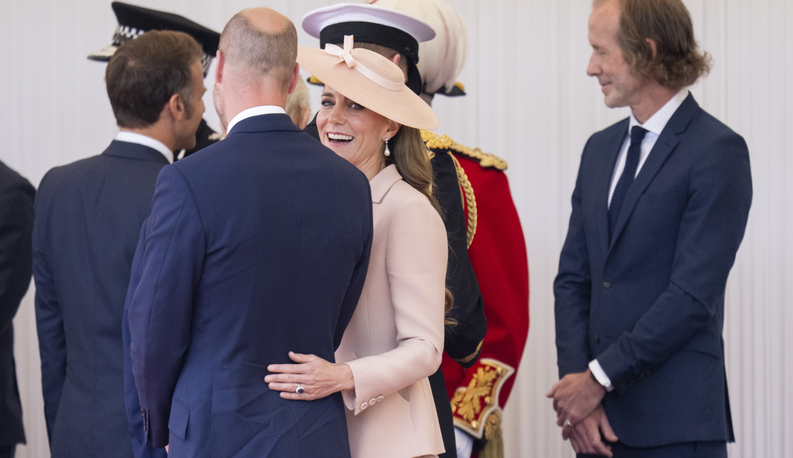 La princesse Catherine jetant un coup d'œil à la caméra alors qu'elle pose affectueusement sa main sur le dos du prince William.