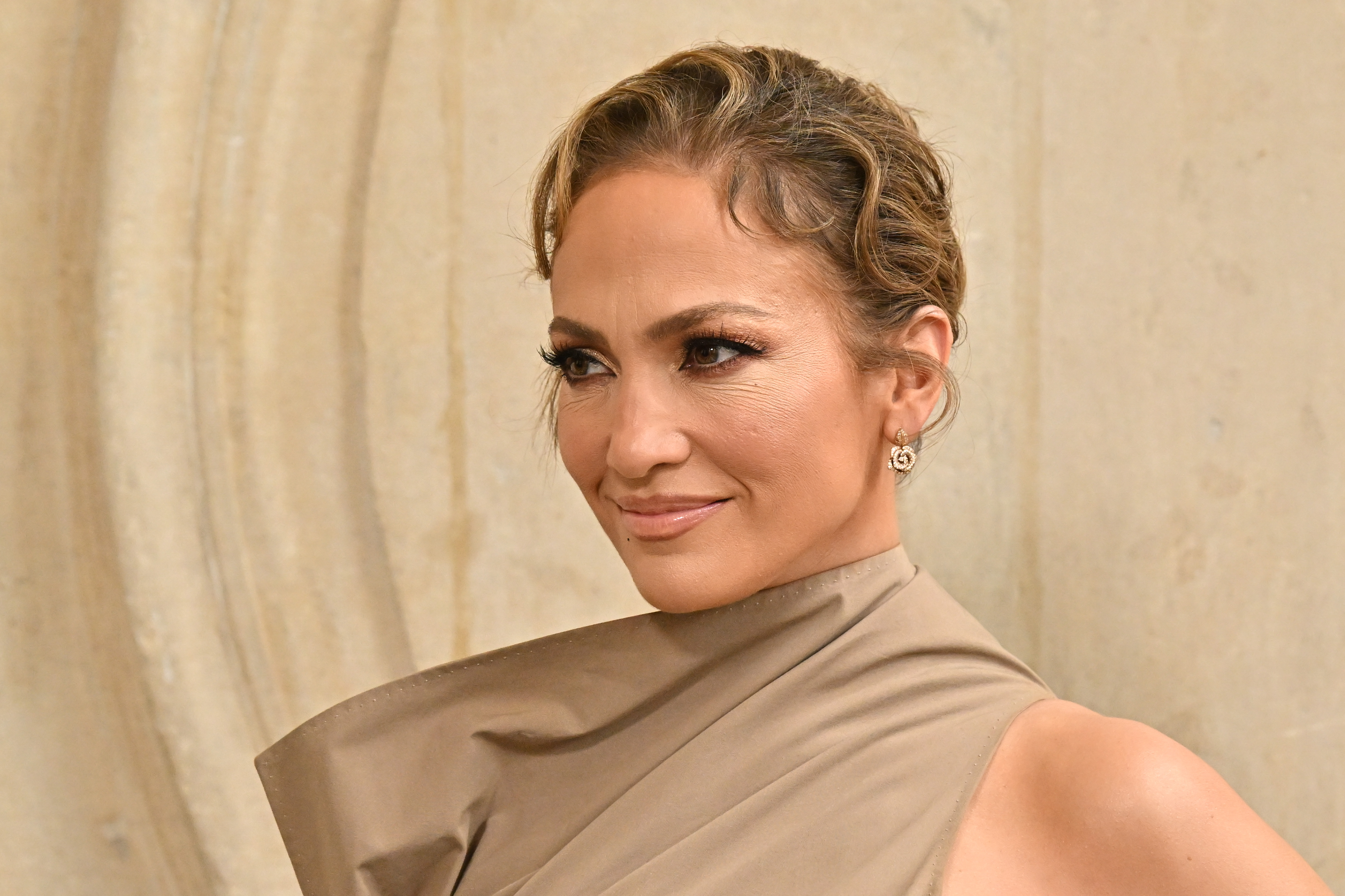 Jennifer Lopez affiche un léger, mais sérieux sourire au défilé Haute Couture Automne/Hiver 2024 de Christian Dior lors de la semaine de la mode à Paris le 24 juin 2024 | Source : Getty Images