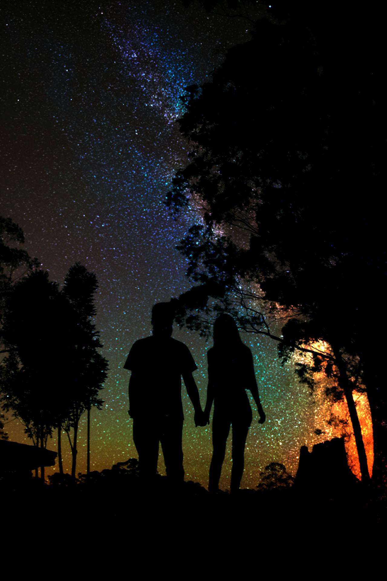 Silhouette d'un couple se tenant par la main la nuit | Source : Pexels