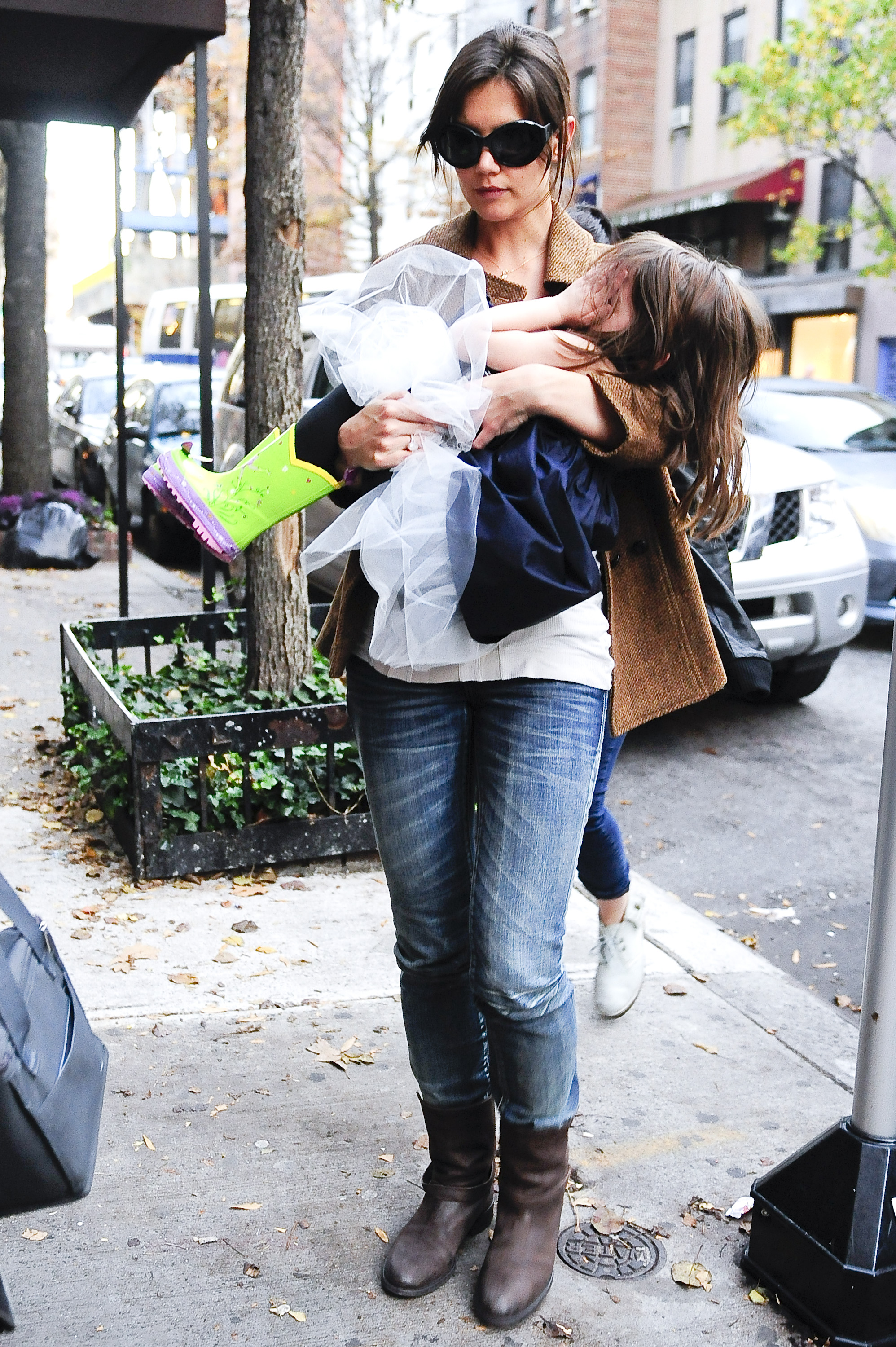 Katie Holmes porte Suri Cruise, qui se couvre le visage, alors qu'elles se promènent dans Greenwich Village le 22 novembre 2009 | Source : Getty Images