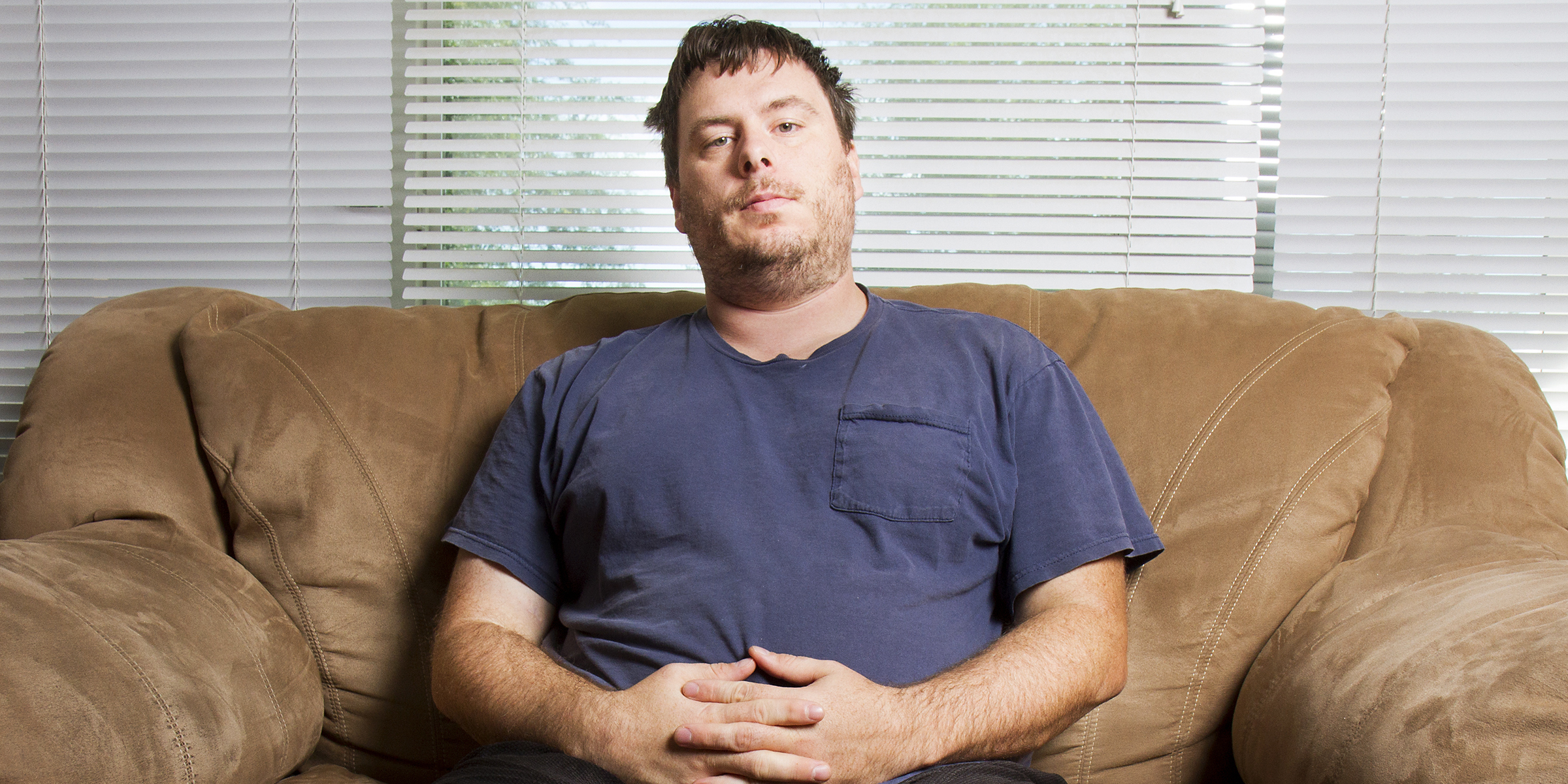 Homme se relaxant sur le canapé | Source : Shutterstock