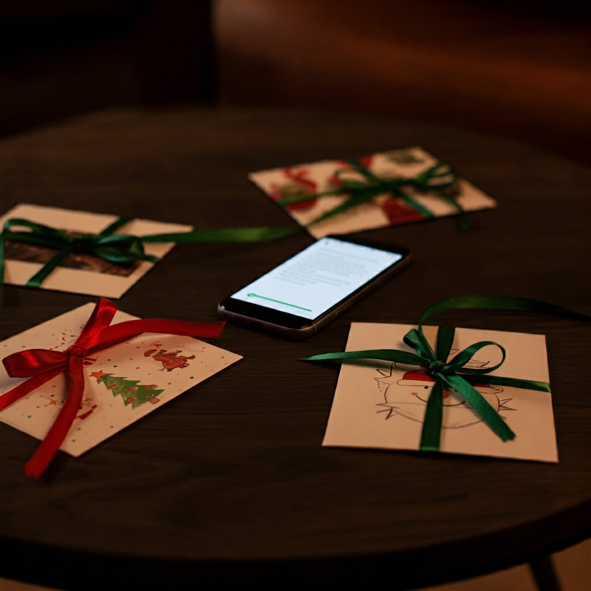 Une table basse avec un téléphone entouré de cartes de Noël | Source : Gemini