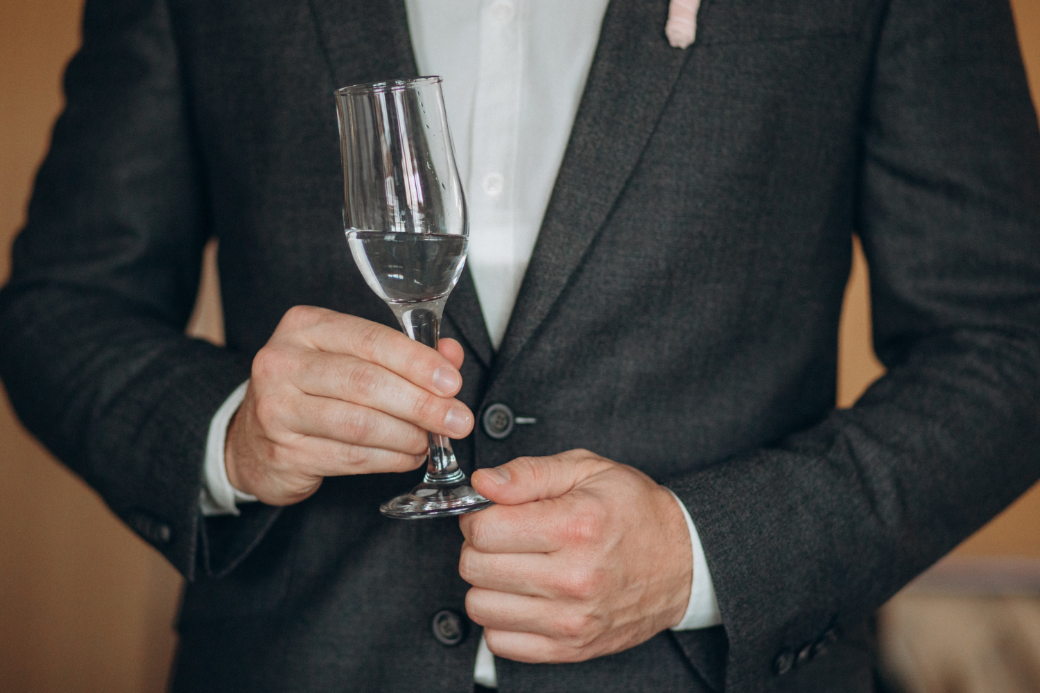 Un homme tenant une flûte de champagne | Source : Freepik