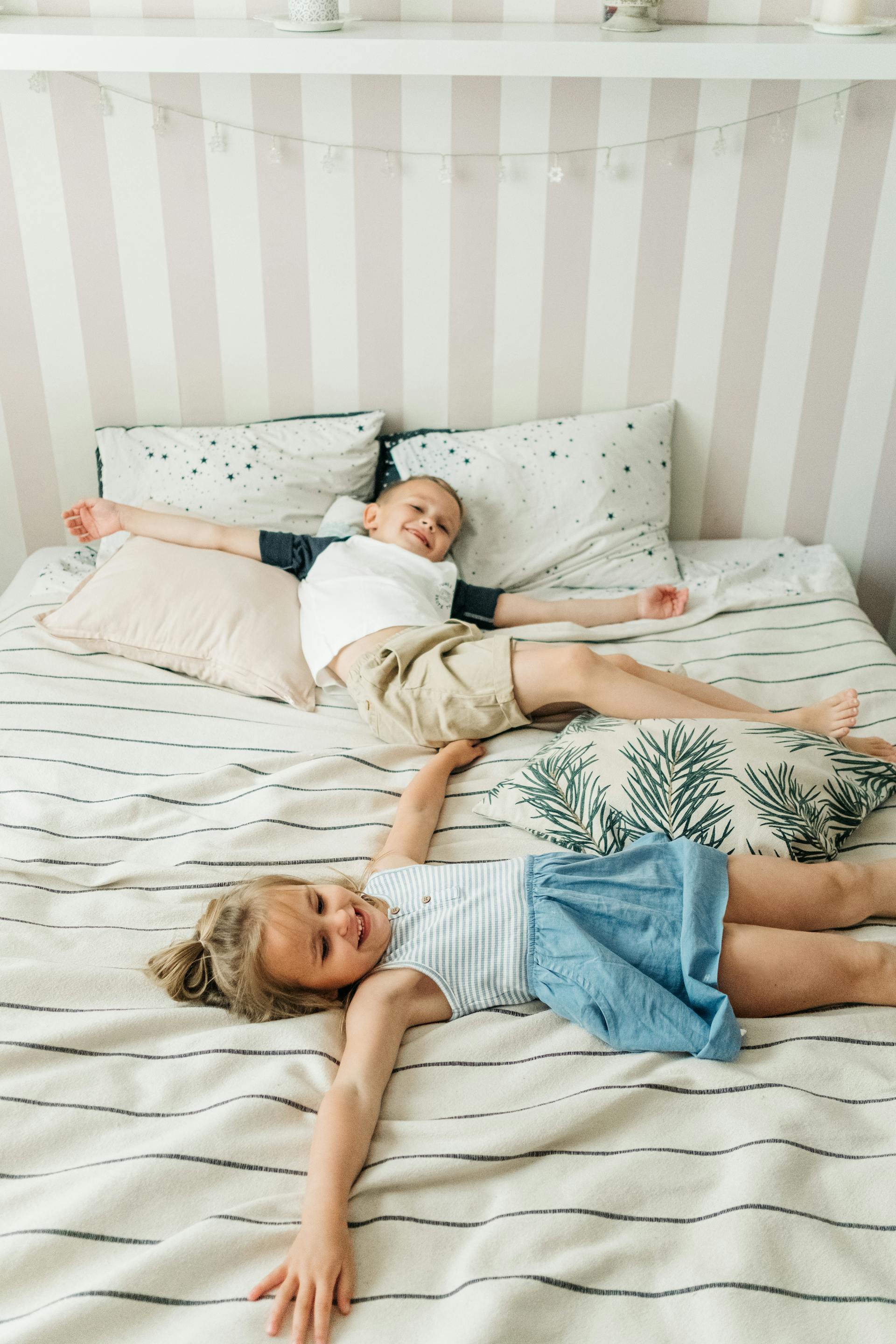 Des enfants allongés sur le lit | Source : Pexels