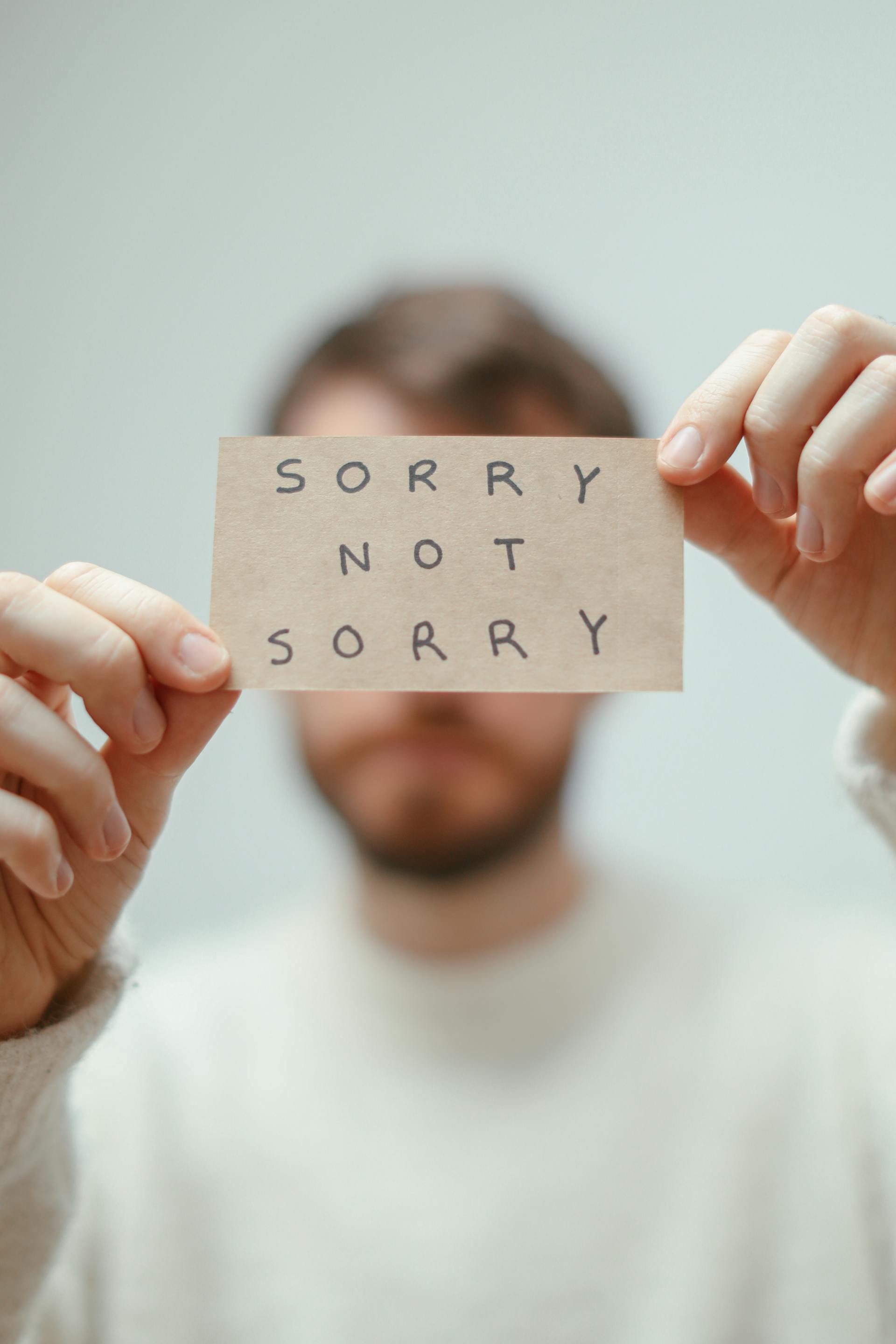Un homme tenant un papier sur lequel est écrite une phrase | Source : Pexels