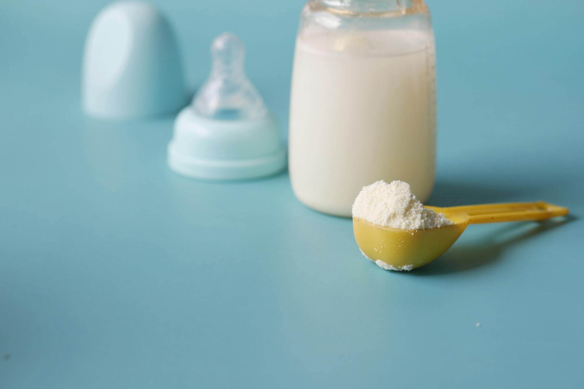 Gros plan sur la mangeoire d'un bébé et sur une cuillerée de lait maternisé en poudre | Source : Pexels