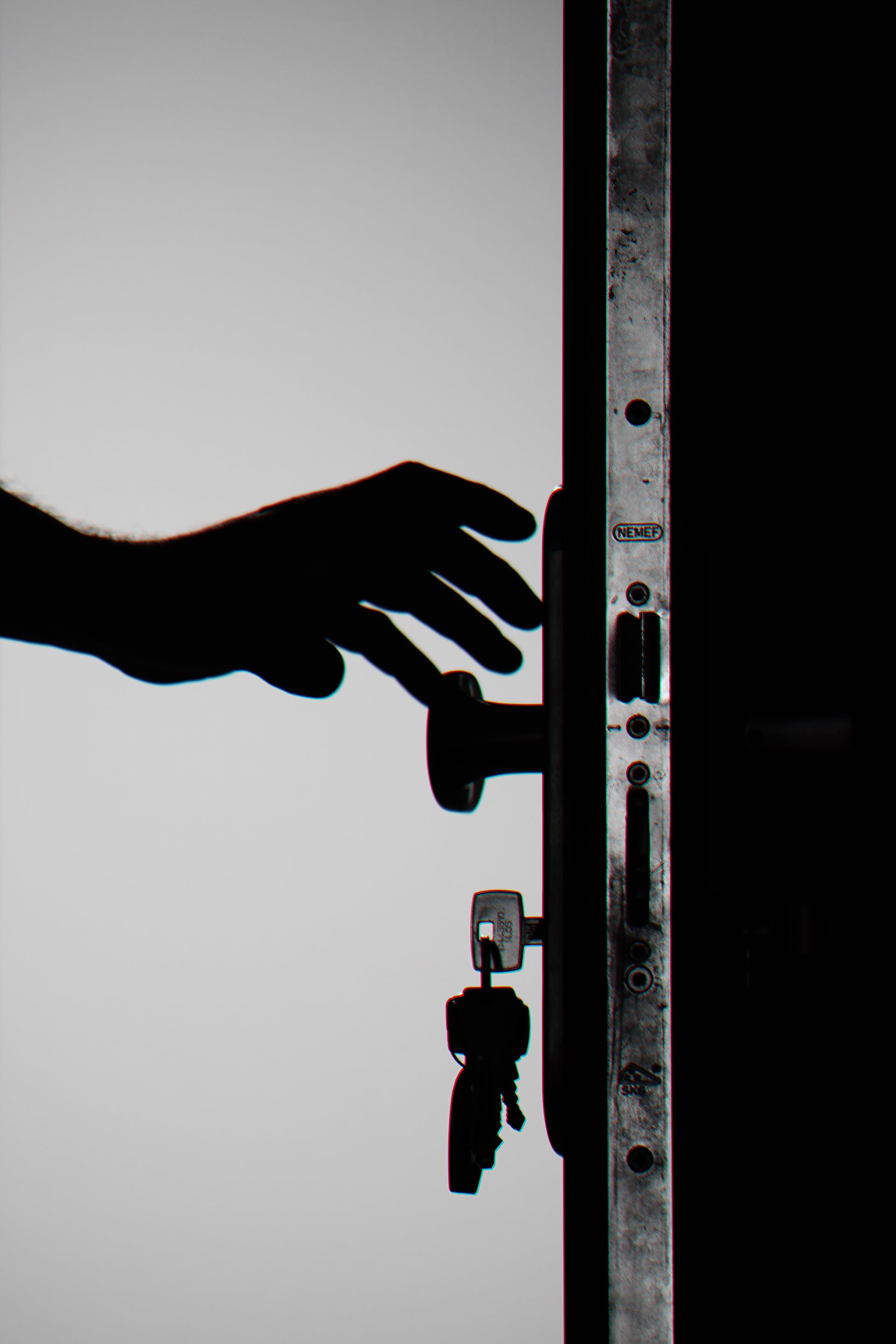 Silhouette d'une personne tenant un bouton de porte avec les clés à l'intérieur | Source : Pexels