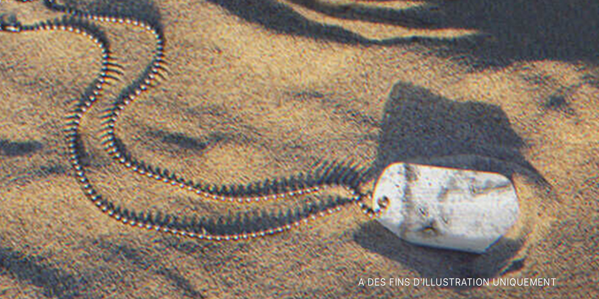 Un vieux collier militaire dans le sable | Source : Shutterstock